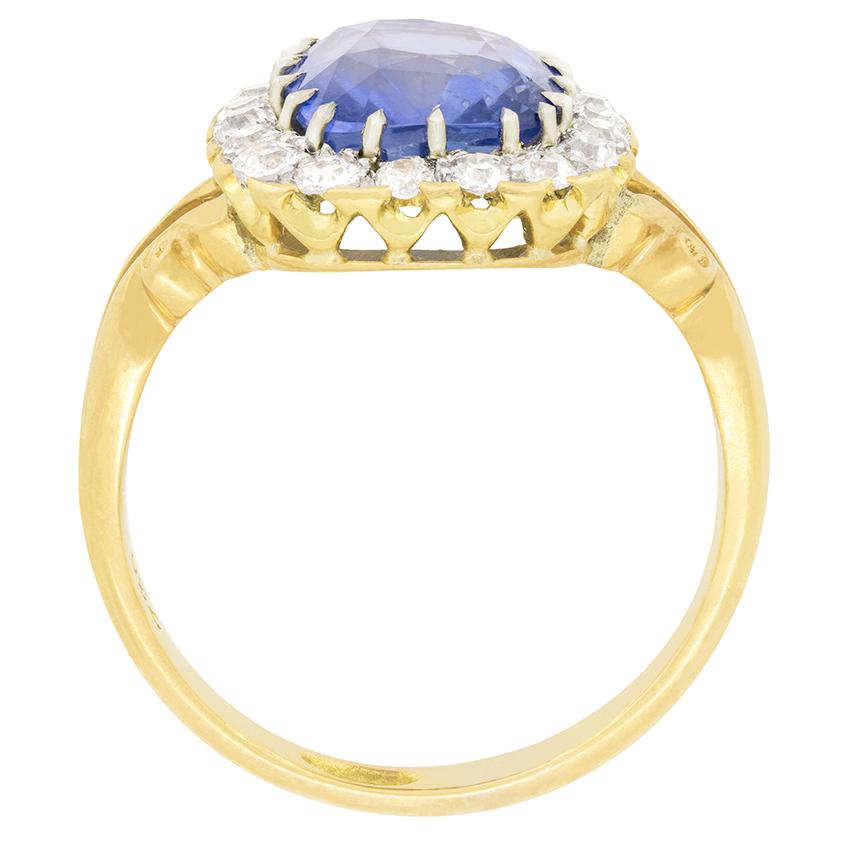 A stunning Natural Sri Lankan Sapphire is central to this Art Deco coronet cluster ring. The cushion cut sapphire is a wonderful cornflower blue in colour and weighs 4.54 carat. Claw set into platinum and surrounded by a halo of old cut diamonds. A