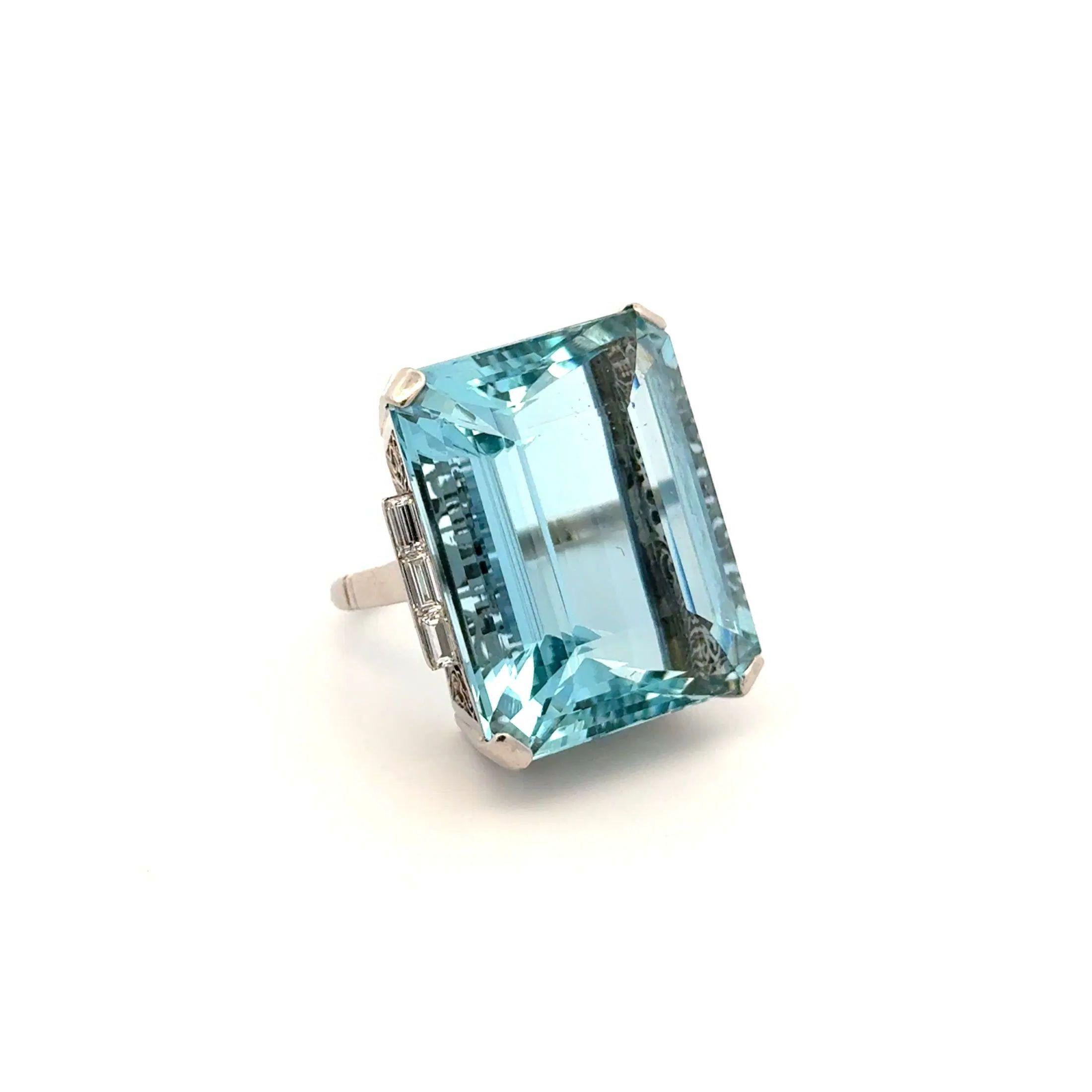 Simply Beautiful! Art Deco Aquamarine and Baguette Diamond Platinum Vintage Statement Ring. Centering a securely nestled Hand set Fabulous Emerald Cut Aquamarine, weighing approx. 46.88 Carat. Both sides of ring Hand set with Baguette Diamonds. Hand