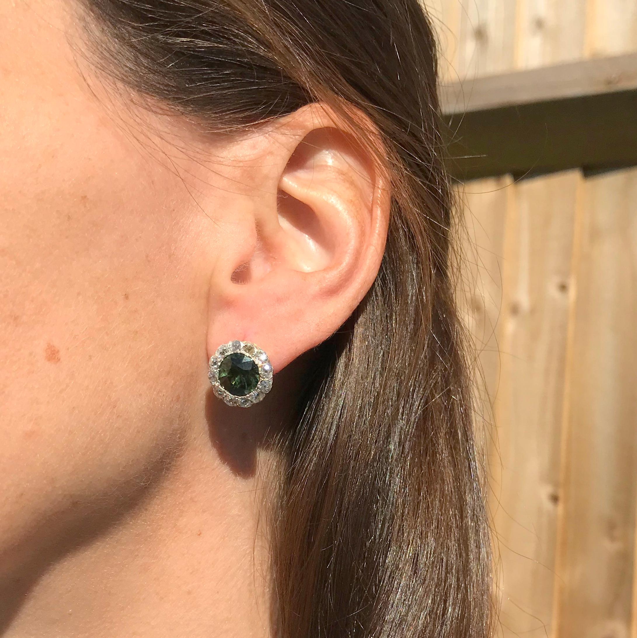 Top grade natural sapphire earrings. The perfectly matched old cut green sapphires – certified as natural and without heat treatment – display a rich, olive-y green, the colour of which is emphasised by the surrounding border of twelve high white