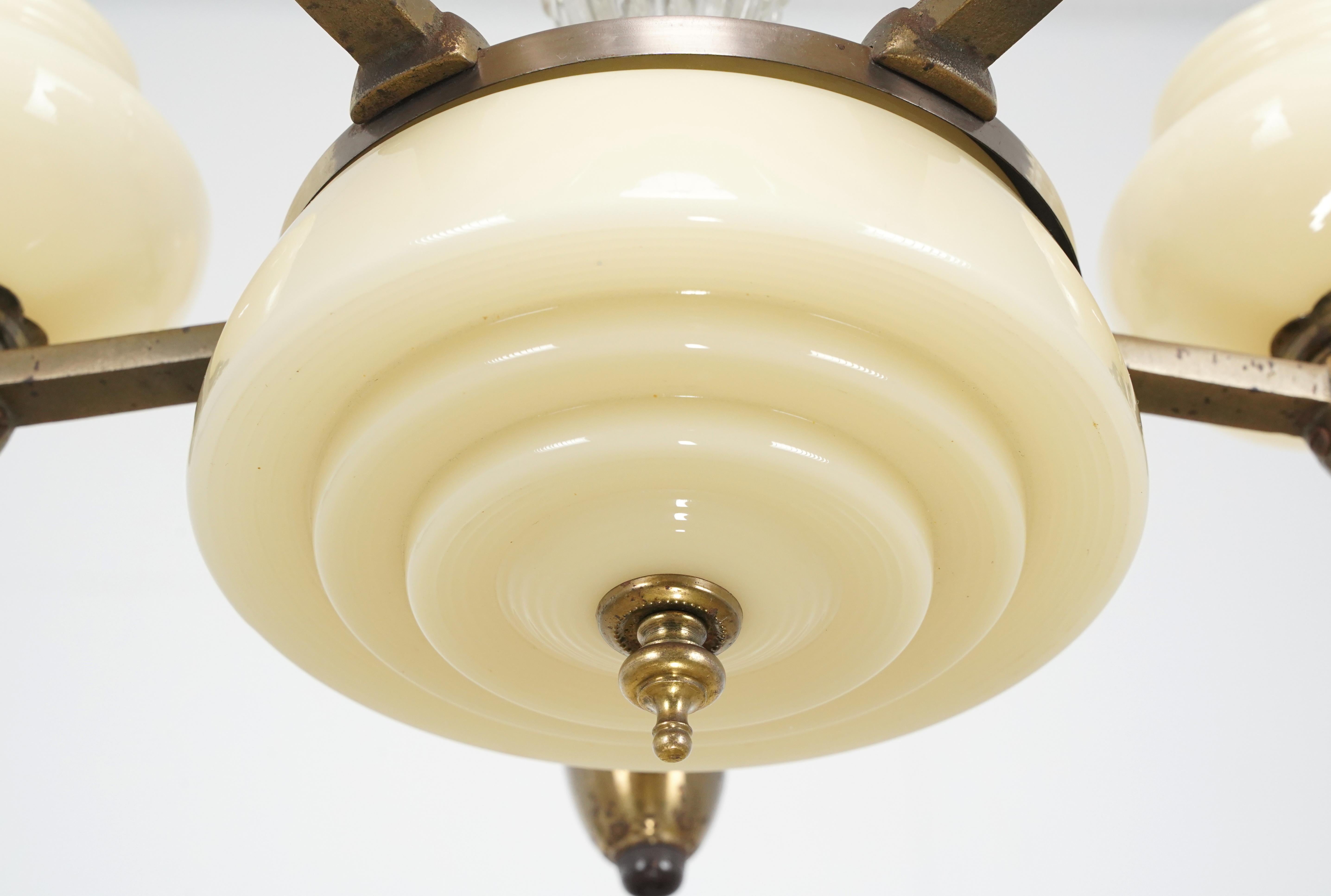 Art Deco style chandelier with a brass plated steel and clear glass frame, and tan glass slip shades. This light requires five standard Edison style medium base bulbs. This will be cleaned and restored before shipping. Good condition. One available.