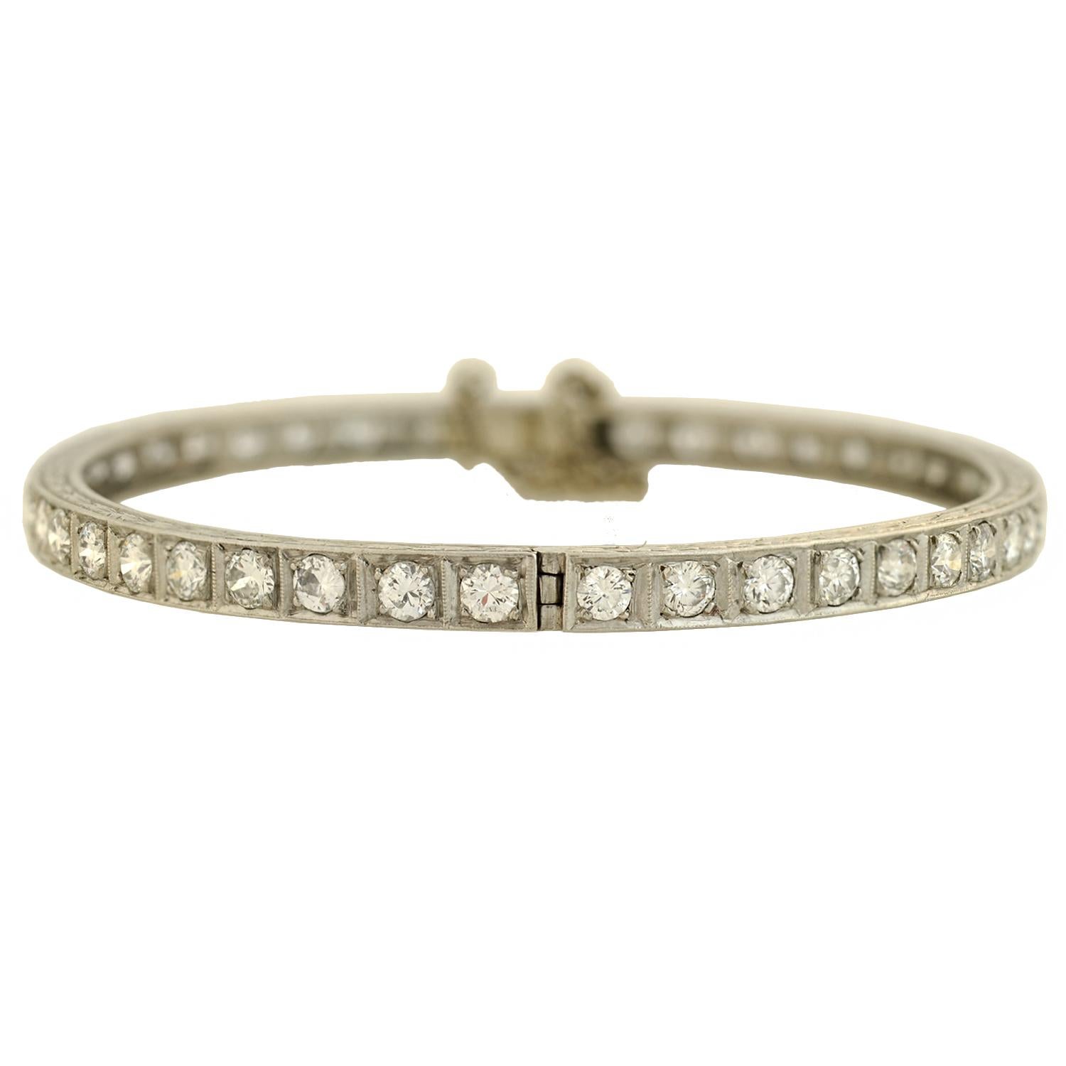 A beautiful diamond bangle bracelet from the Art Deco (ca1920) era! This stunning piece is crafted in platinum and lined with sparkling old European Cut diamonds. Each stone is prong set in a box setting, mimicking the look of a classic line