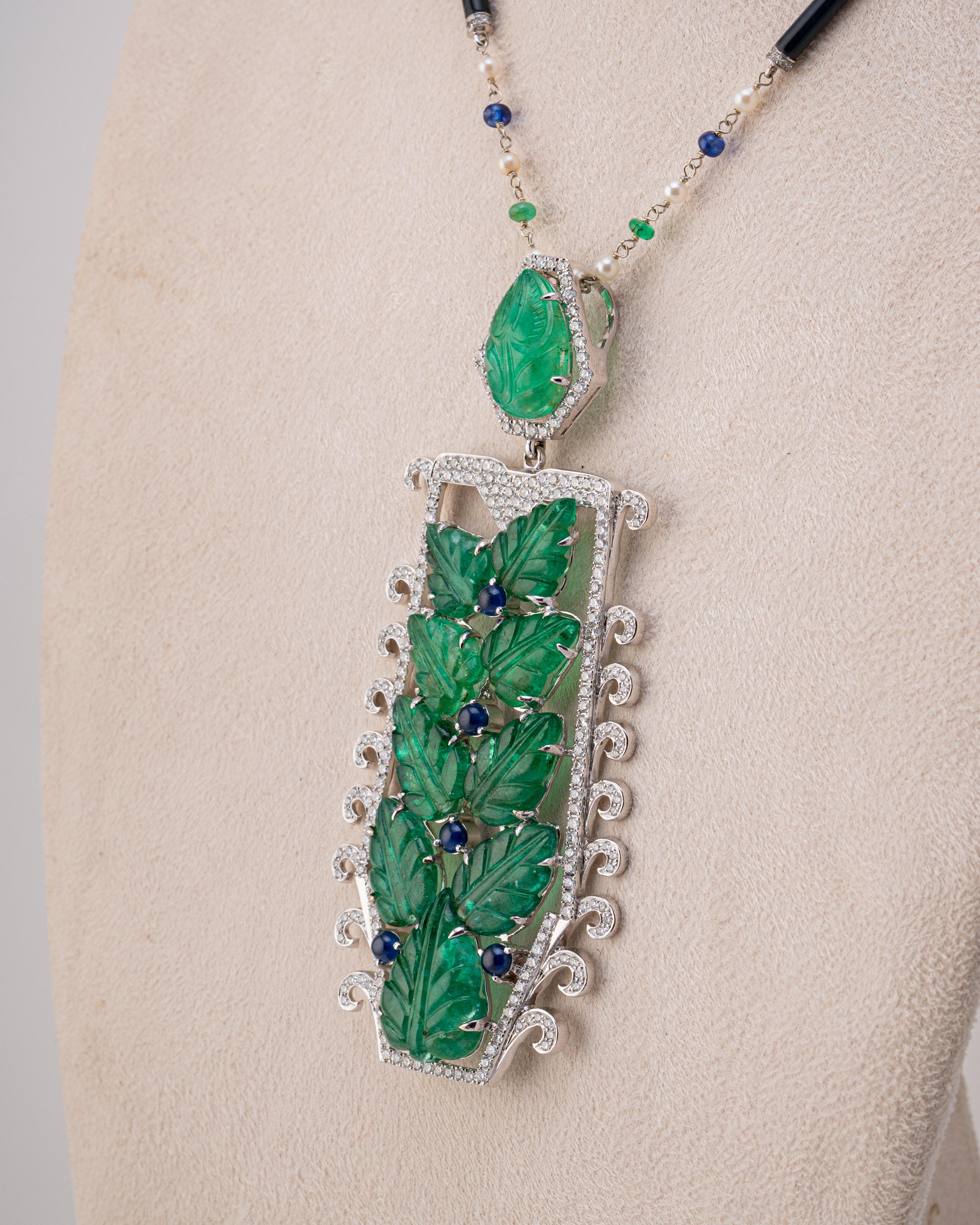 An art-deco looking 53 carat Zambian Emerald, 1.73 carat Blue Sapphire and 4.05 carat White Diamond Pendant Necklace, with a Black Onyx, Pearl, Blue Sapphire and Emerald chain all set in 18K White Gold. the chain is currently 30 inches long, but it