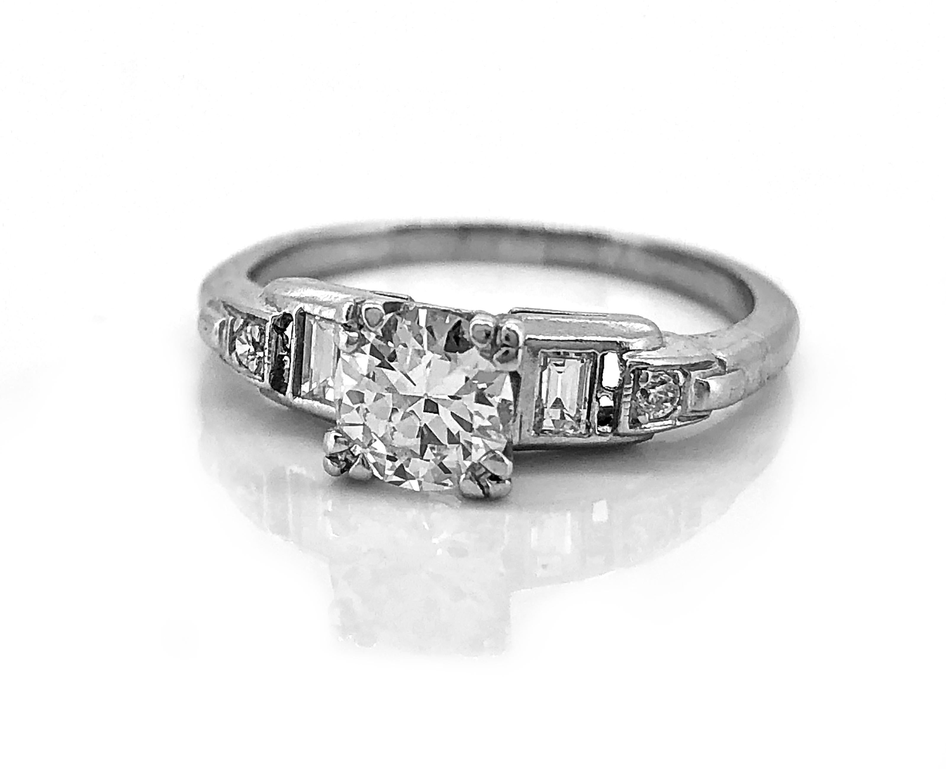 Beautiful baguettes frame this .55ct. diamond and the antique engagement ring is further enhanced by the rectangular cut-outs just beneath the baguettes. Crafted in platinum and accented with small diamonds at the beginning of the design portion of