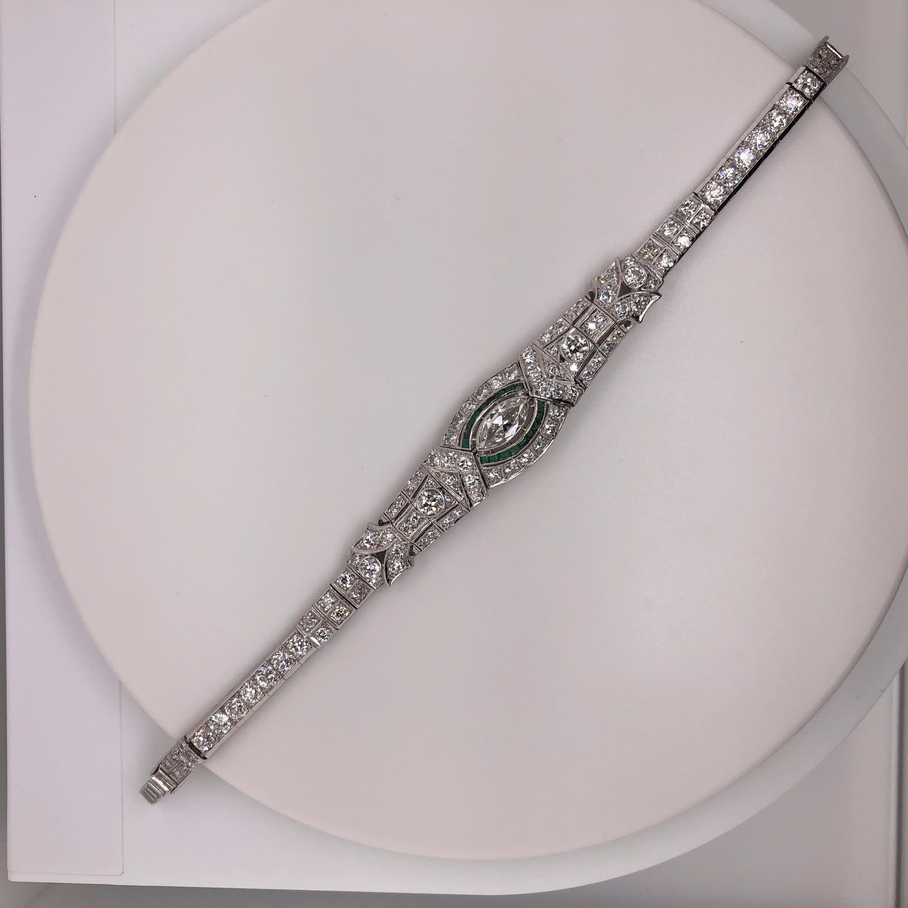 Original Art Deco bracelet containing approximately 5.75 total carats of Old European Cut, Old Mine Cut, Single Cut and baguette cut diamonds. The bracelet is accented with French cut emeralds surrounding the center marquise cut diamond. The center