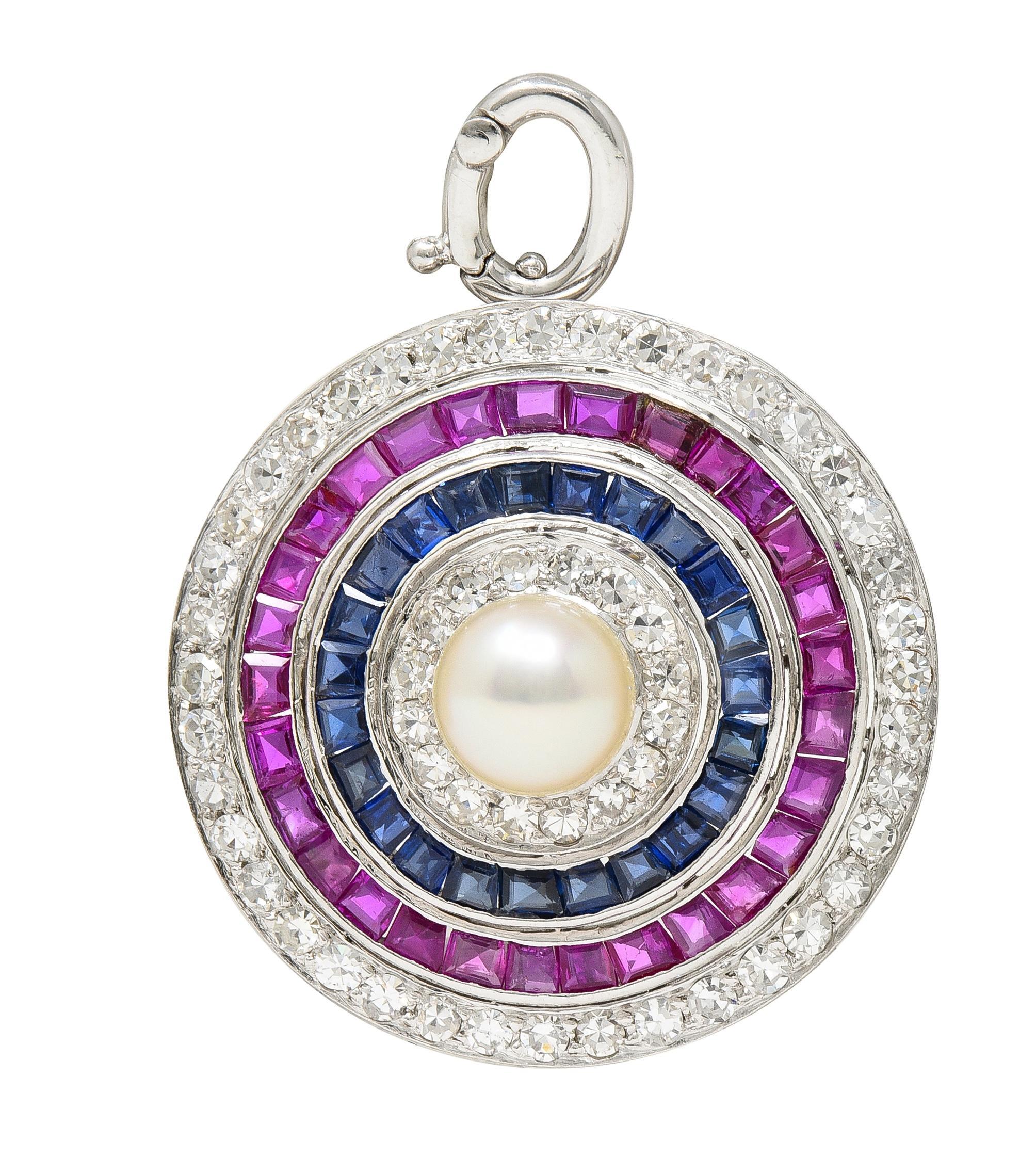 Designed as a tiered circular form centering a 8.0 mm round pearl 
Cream in body color with strong iridescence and excellent luster
With alternating tiers of diamonds, rubies, and sapphires 
Diamonds weigh approximately 1.68 carats total 
G/H color