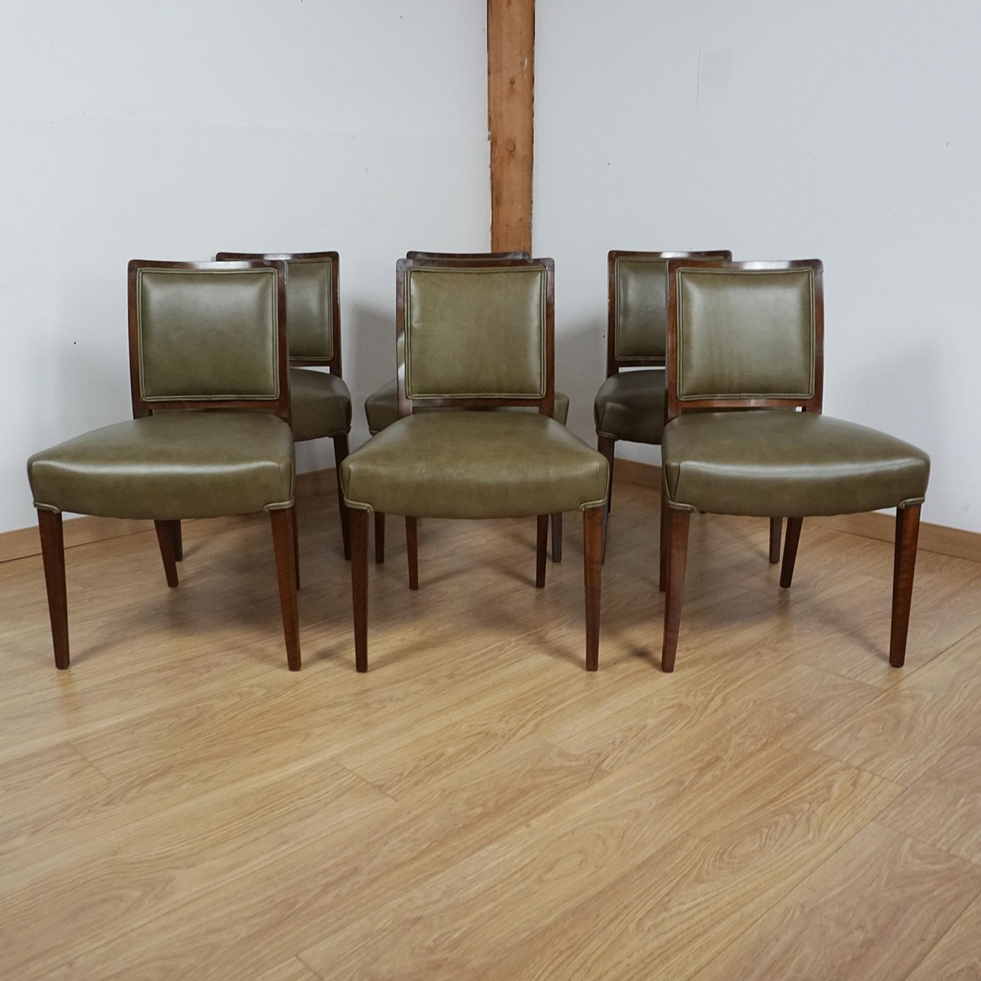 Una suite da pranzo a sei posti in stile Art Déco di Betty Joel. Tavolo impiallacciato in noce australiano con base curva a gradini. Sei sedie da pranzo in noce massiccio con rivestimento in pelle verde. Etichetta del produttore sul lato inferiore