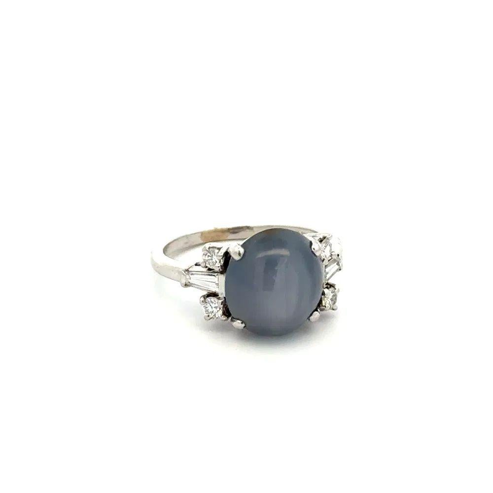 Simply Beautiful! Finely detailed Awesome Bluish Grey Star Sapphire and Diamond Platinum Art Deco Ring. Centering a securely nestled Hand set Bluish Grey Star Sapphire, weighing approx. 6 Carats. Accented either side by Baguette and Round Brilliant