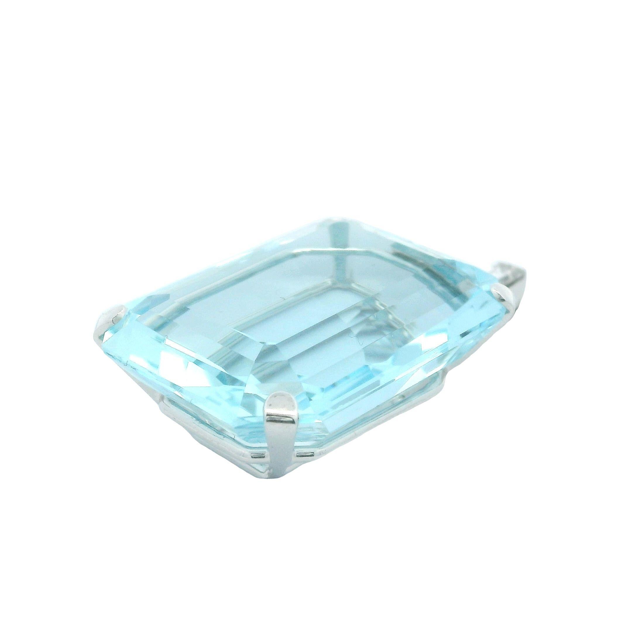 This exquisite art deo statement piece of jewelry is offered by Alex & Co. This pendant showcases a four prong double basket set blue aquamarine octagonal step cut weighing approximately 60ct and measuring 29.35 X 22.46 X 12.74 mm. This stunning