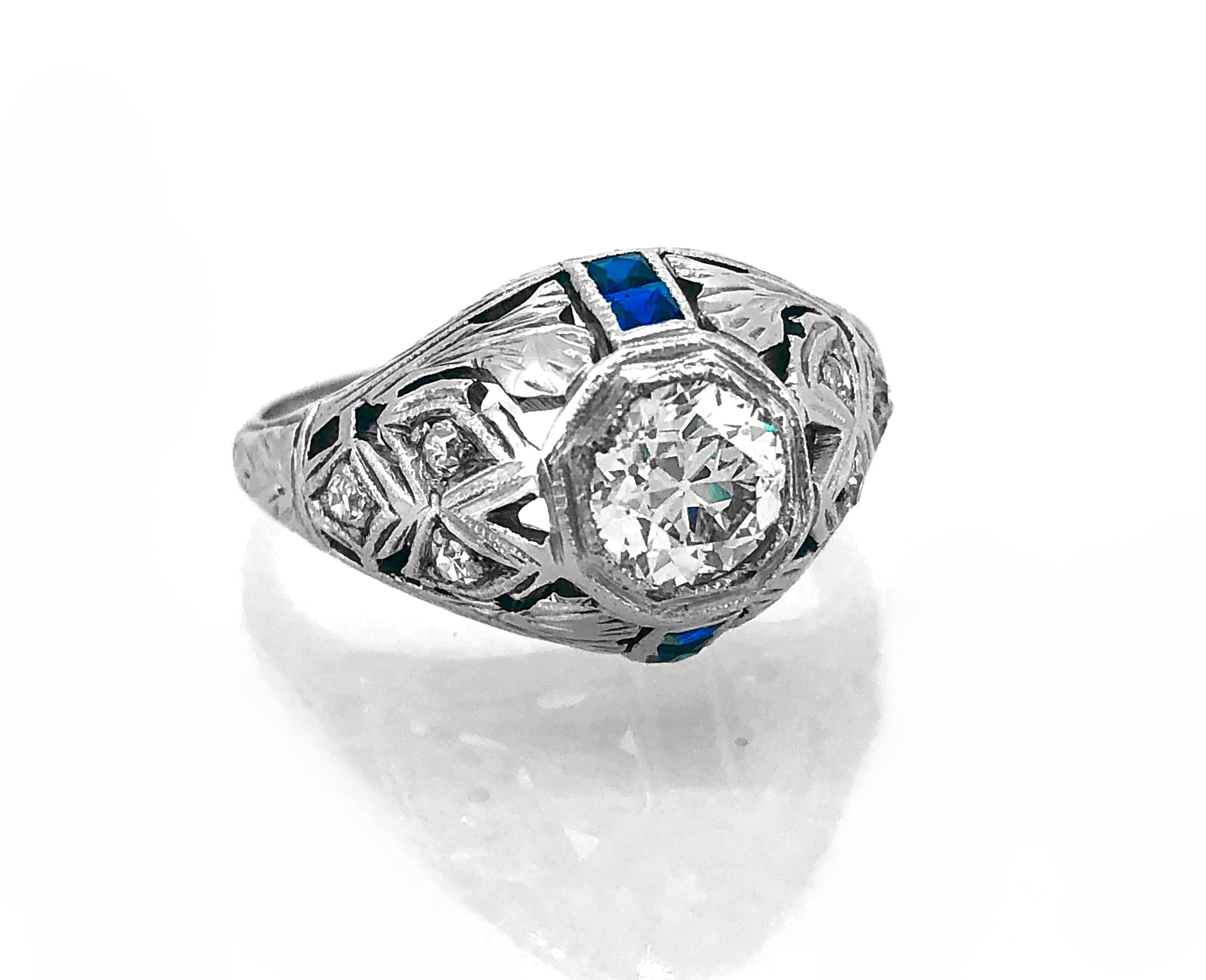 A beautifully designed & constructed Diamond & Sapphire Art Deco antique engagement ring. It features a .65ct. apx. VS2 clarity and J color center European cut diamond with .06ct. T.W. apx. diamonds on the shank. It is beautifully accented with