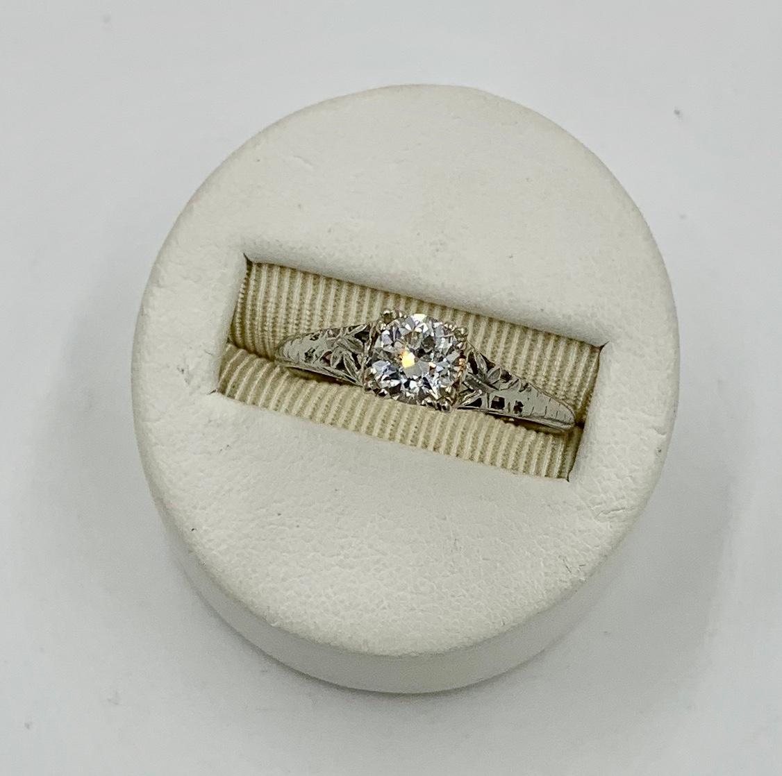 This is a stunning Antique Art Deco - Edwardian Diamond Ring set with a spectacular .65 Carat Old European Cut Diamond in a beautiful open work setting in 18 Karat White Gold.  The Old European Cut Diamond is absolutely stunning with the brilliant