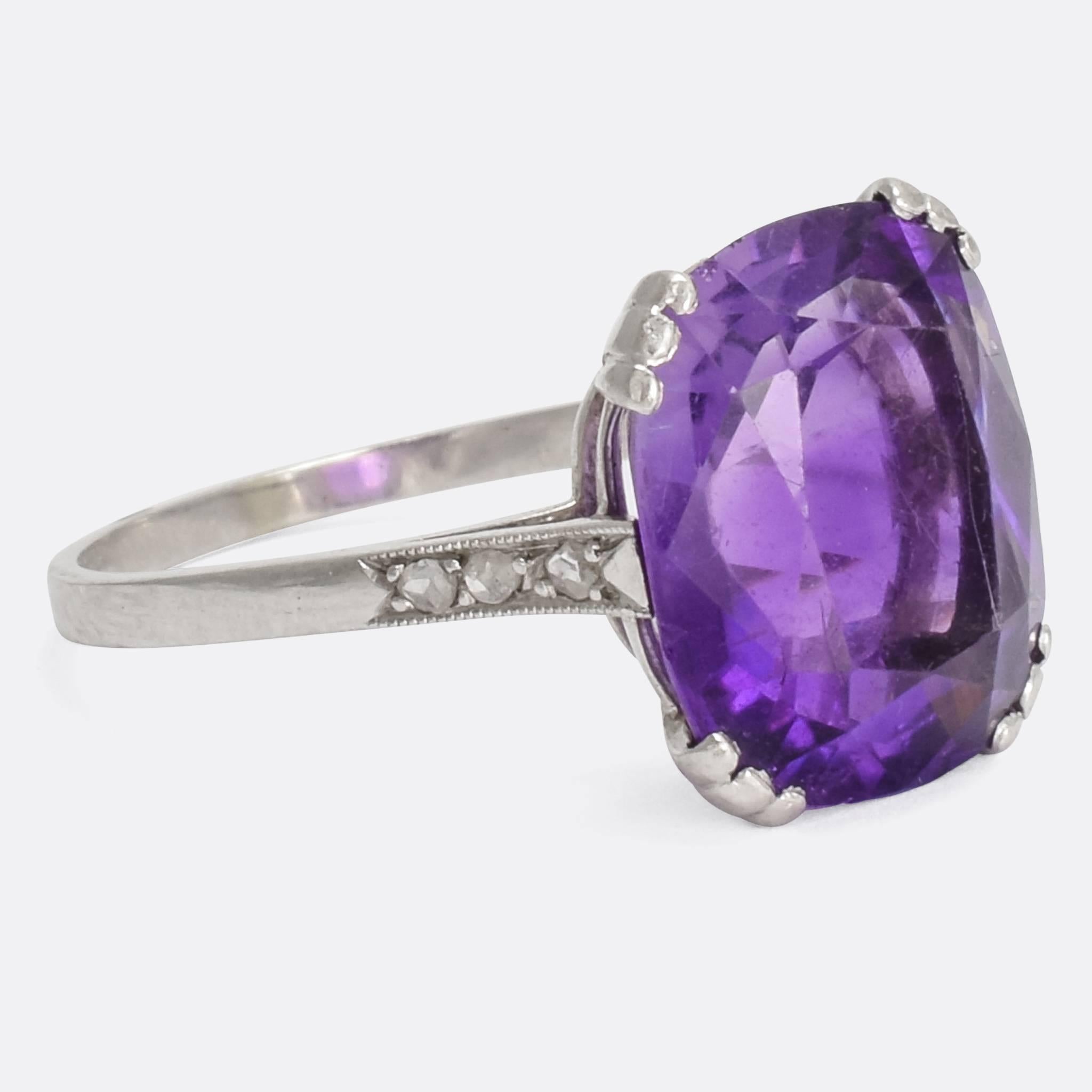 A show-stopping 1930s Art Deco statement ring, set with a 6.75 carat Siberian Amethyst and modelled in platinum throughout. With rose cut diamond millegrain shoulder accents and embellished triple claws, the piece is a wonder to behold. Very typical