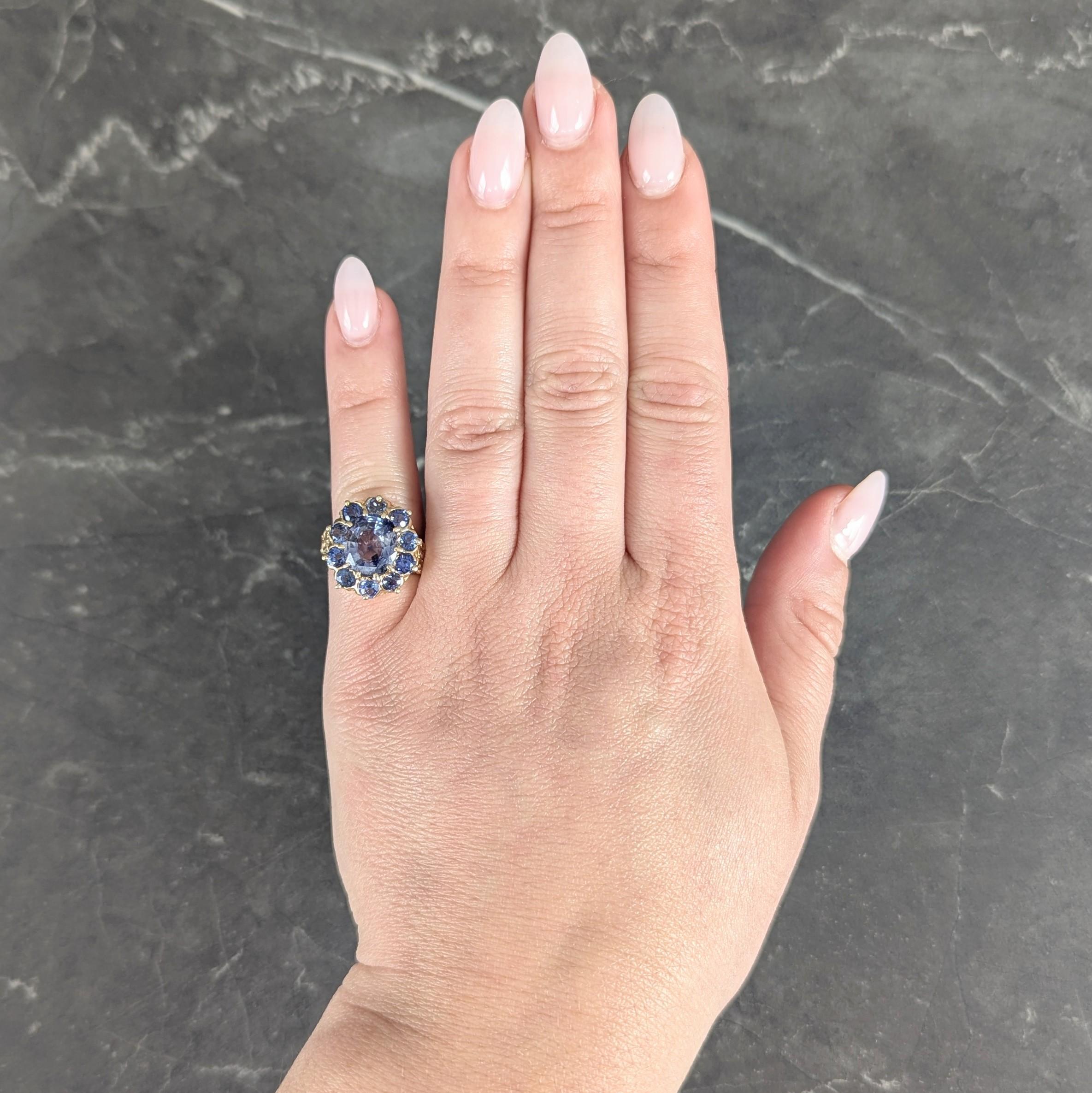 Centering a mixed oval cut sapphire weighing approximately 4.30 carats total - transparent medium blue
Natural Madagascar in origin and displaying no indications of heat treatment
Set with yellow gold a talon prongs with a halo surround of round cut