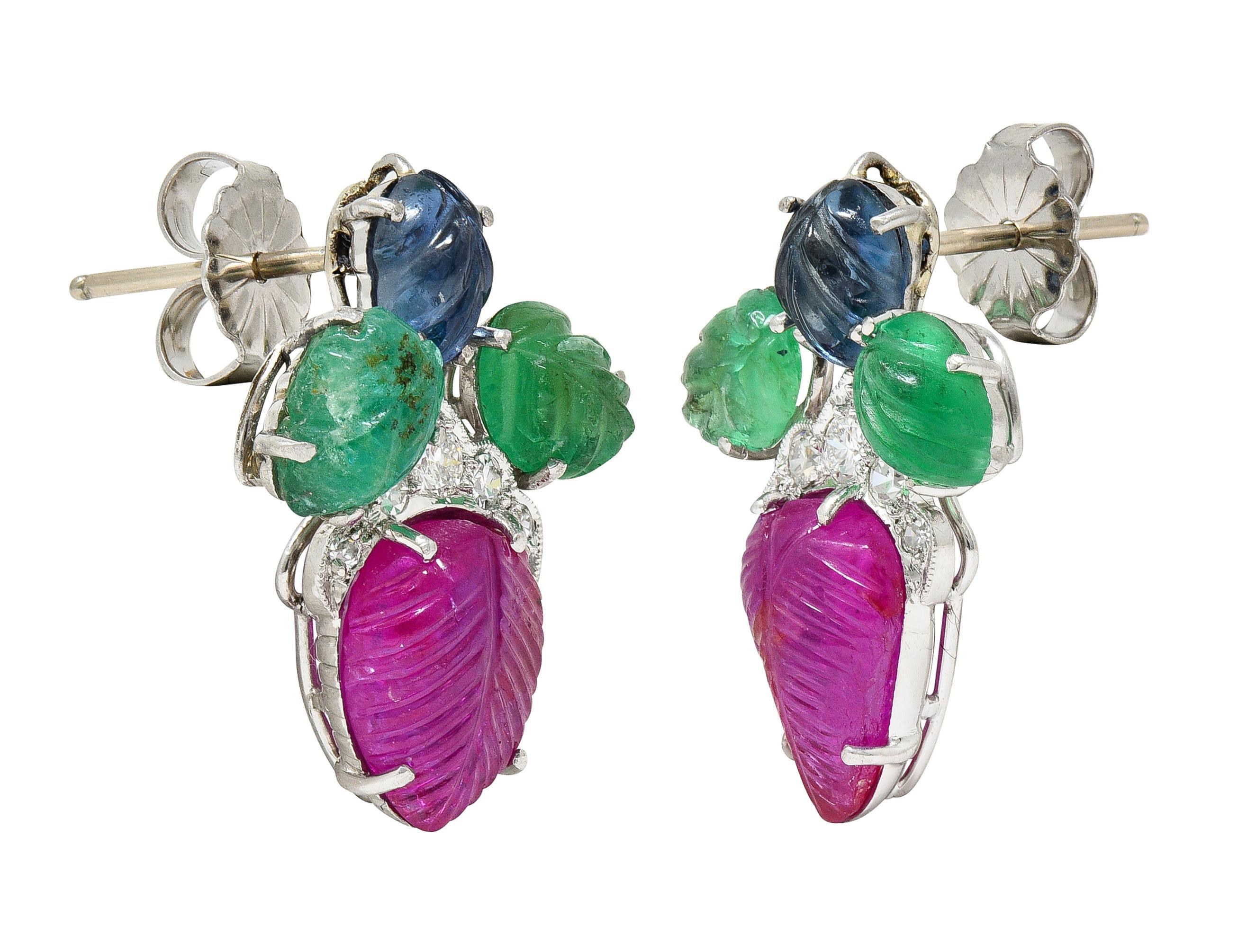 Designed as foliate motif surmounts and drops featuring clustered gemstones
Comprised of prong set and carved foliate motif rubies, emeralds, and sapphires
Rubies weigh approximately 3.28 carats - transparent medium purplish red
Emeralds weigh