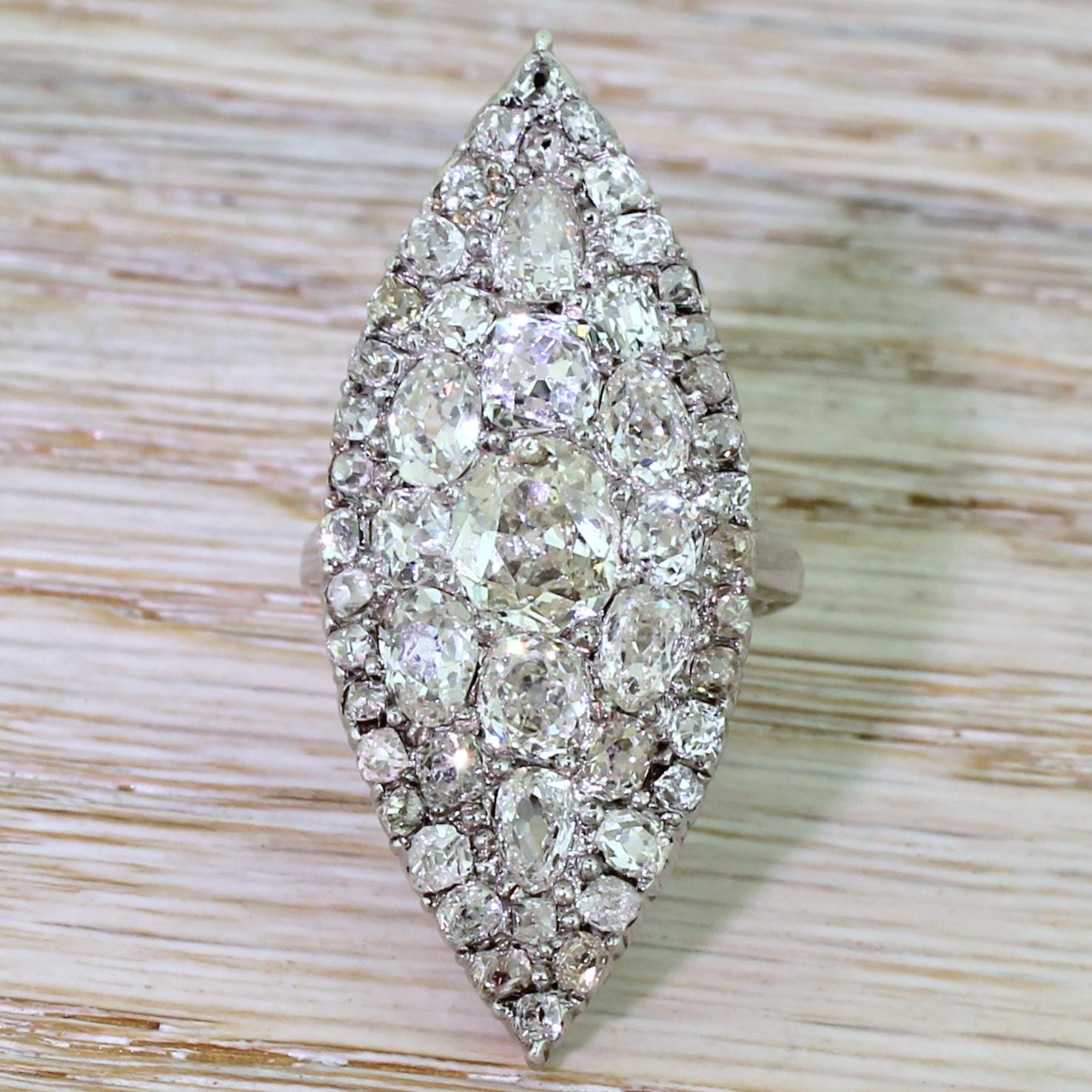 Overstated, unsubtle, brash – but oh my do we approve! Pieced together like a jigsaw, this gloriously decadent navette cluster features fifty one old cut diamonds of varying cuts and sizes to form a finger full of bling. The diamonds are bead and