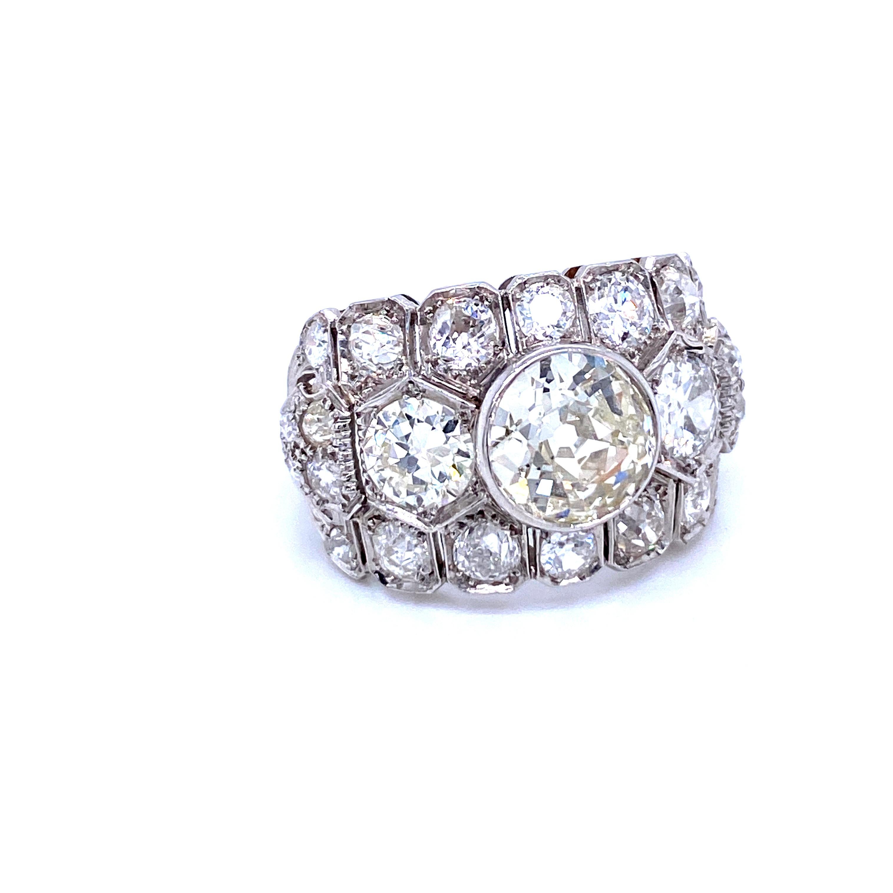 An exquisite example of Art Deco jewel, this ring is hand-crafted in 18k white gold, authentic from 1920/1930, featuring in the center a Large sparkling Old mine-cut Diamond weighing 2.50 carats, graded K color SI2, on the two sides two large