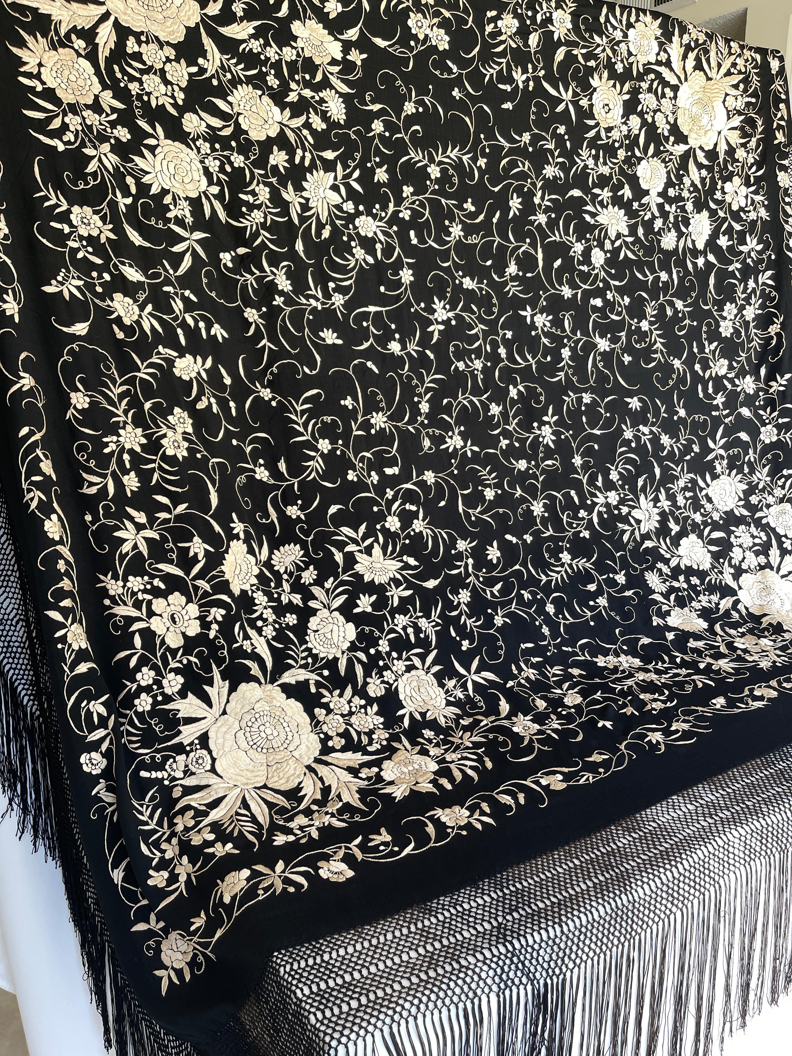 Châle de piano Art déco en soie noire brodée à la main d'un motif floral en soie blanche et d'une frange de soie de 12 pouces nouée à la main. Le châle est visuellement magnifique, doux et luxueux. Dans l'ensemble, les mesures sont de 7 pieds carrés