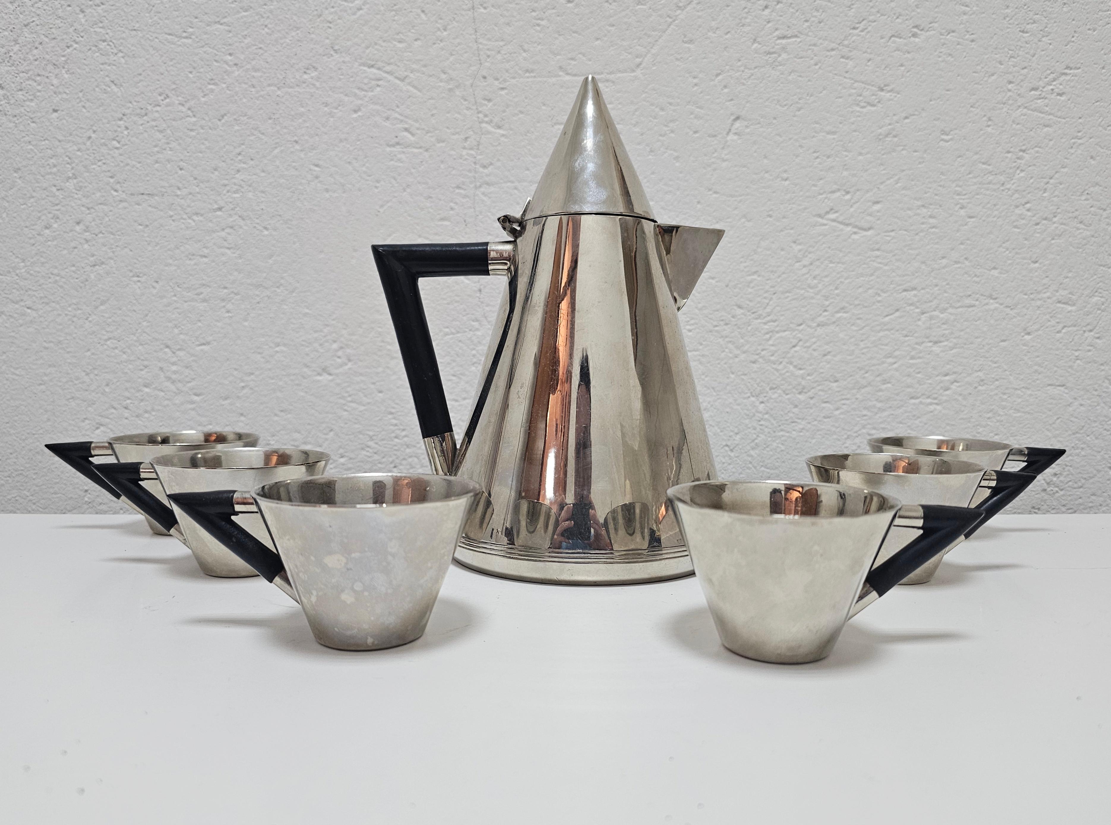 In this listing you can find a beautiful, very rare Art Deco coffee set, consisting of 7 pieces - a serving pot and 6 cups. Crafted with precision, this conical-shaped coffee pot boasts a lustrous silver plated sophistication and charm. The handle,