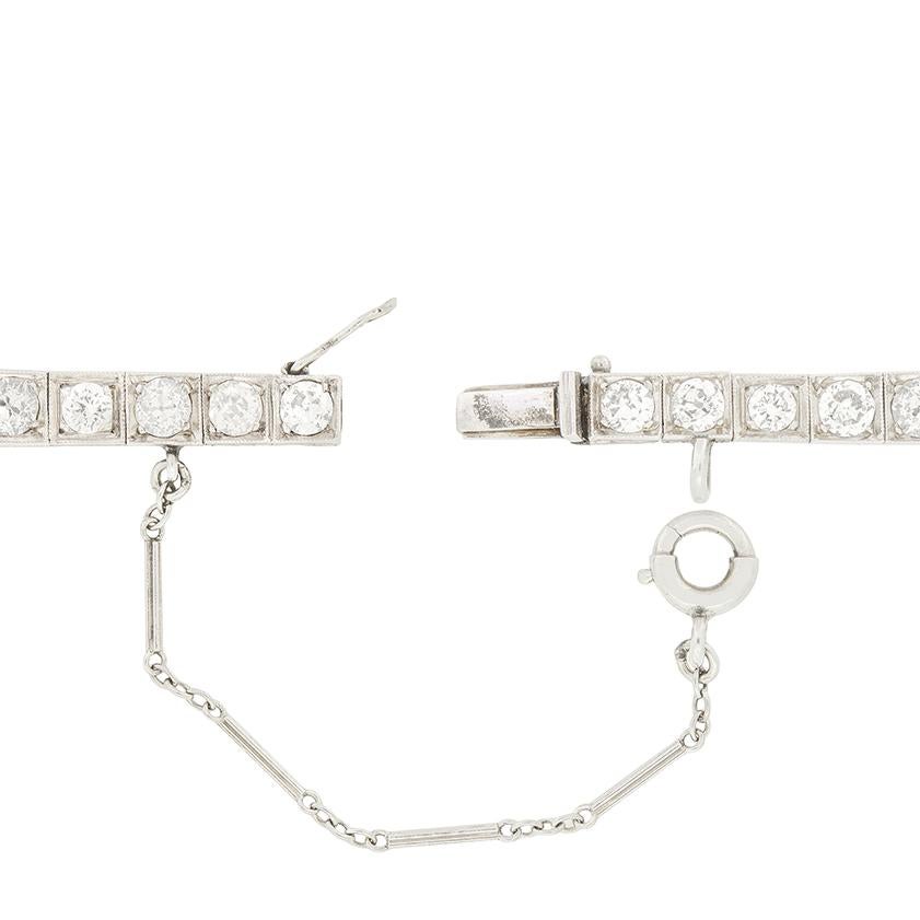 This exquisite Art Deco diamond bracelet is a masterpiece of 1920s craftsmanship. At its heart lies a 1.40ct old cut diamond, rub over set and flanked by two 1.00ct stones. An additional 1.28cts of old cut diamonds surround the trio, across