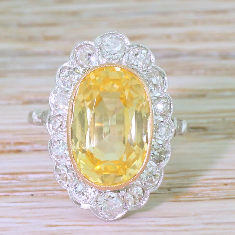 A stunning golden yellow sapphire takes centre stage in this late Deco stunner. The yellow sapphire – certified as natural, unheated and Sri Lankan – is  impressively bright and vivid, and is secured in milgrained rose gold. A graduating surround of