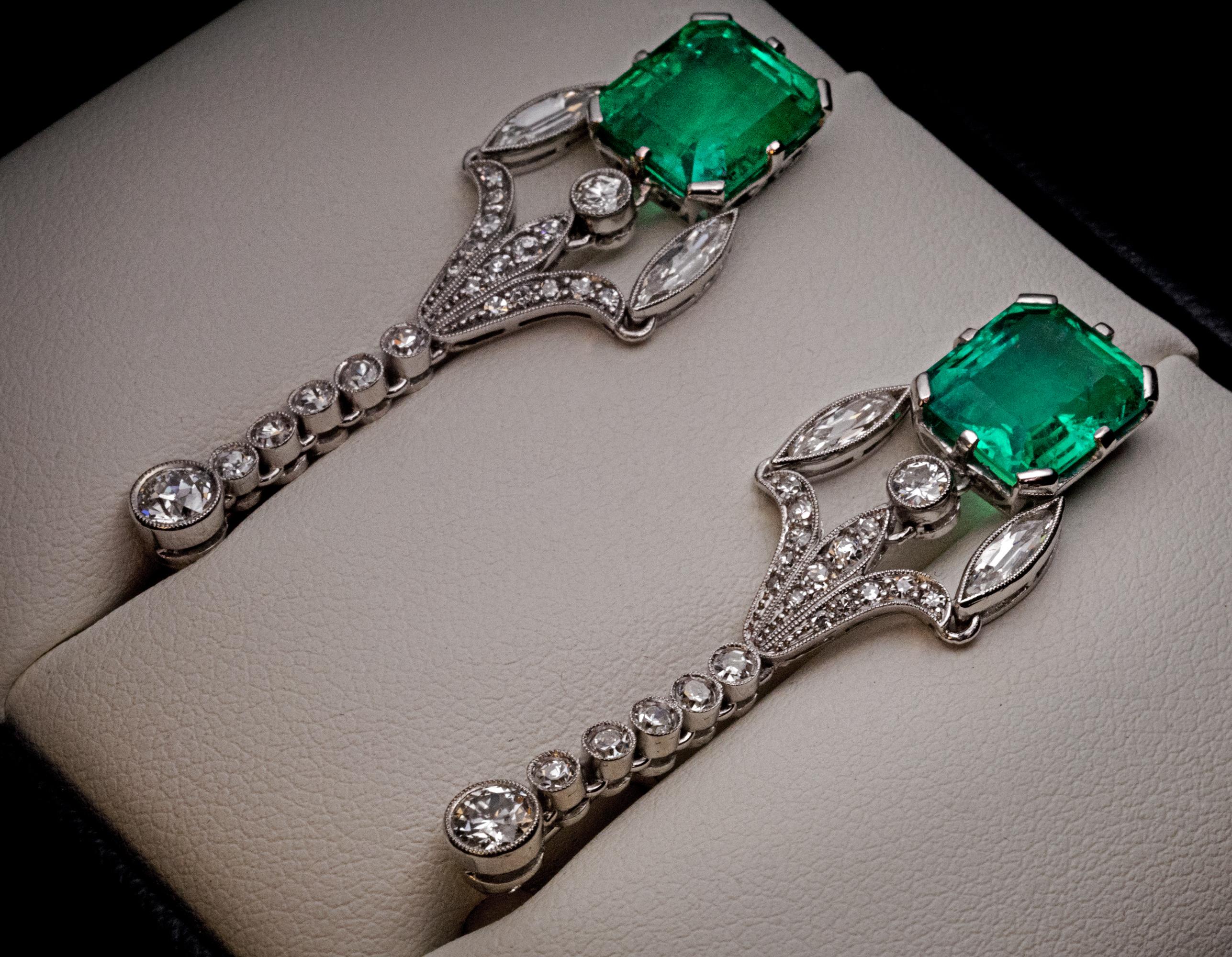 Circa 1920s

These Art Deco era elegant ear pendants are handcrafted in platinum. They feature two Colombian emeralds of excellent color, clarity and sparkle. The emeralds are accented by round and marquise shaped old cut diamonds.

The earrings are