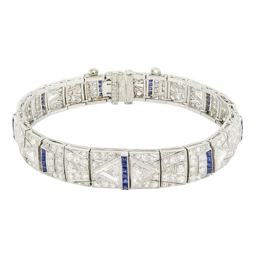 D'une conception enchanteresse, ce superbe bracelet date des années 1920. Le design Art déco est évident avec l'utilisation de motifs géométriques et symétriques créés à partir de diamants et de saphirs contrastés. Le design s'articule autour de