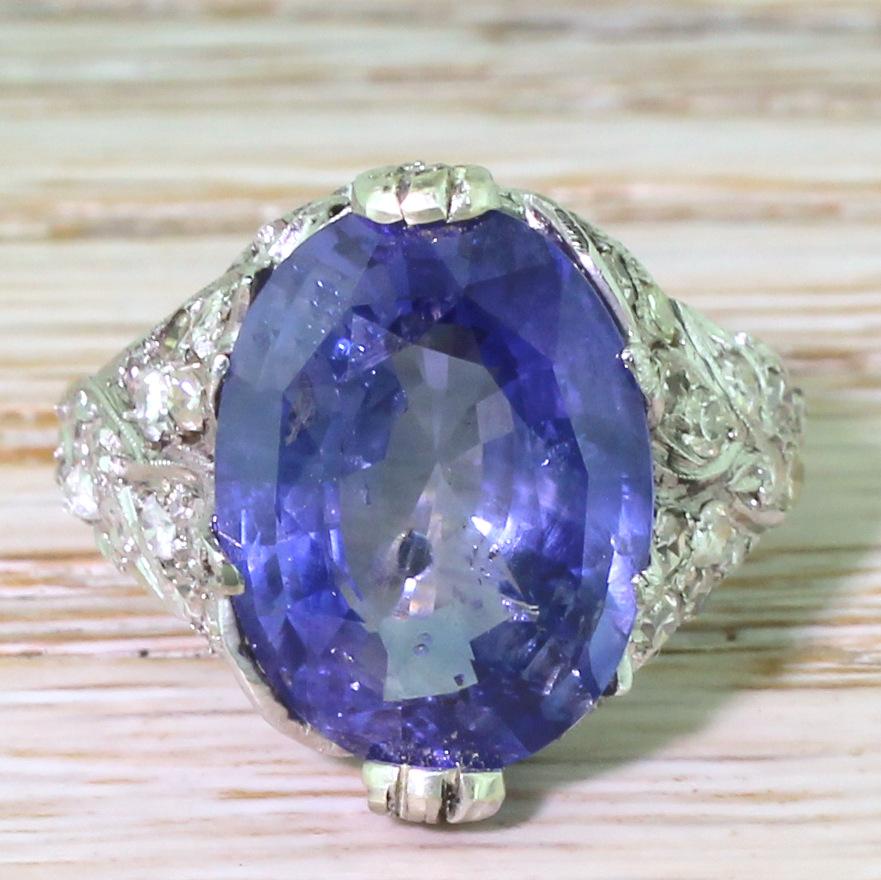 Gloriously individual and highly, highly impressive. The natural and unheated Ceylon sapphire is a delightful cornflower blue with plenty of life and lustre. The central stone is secured in a flamboyant mount with overlapping diamond set leaves in