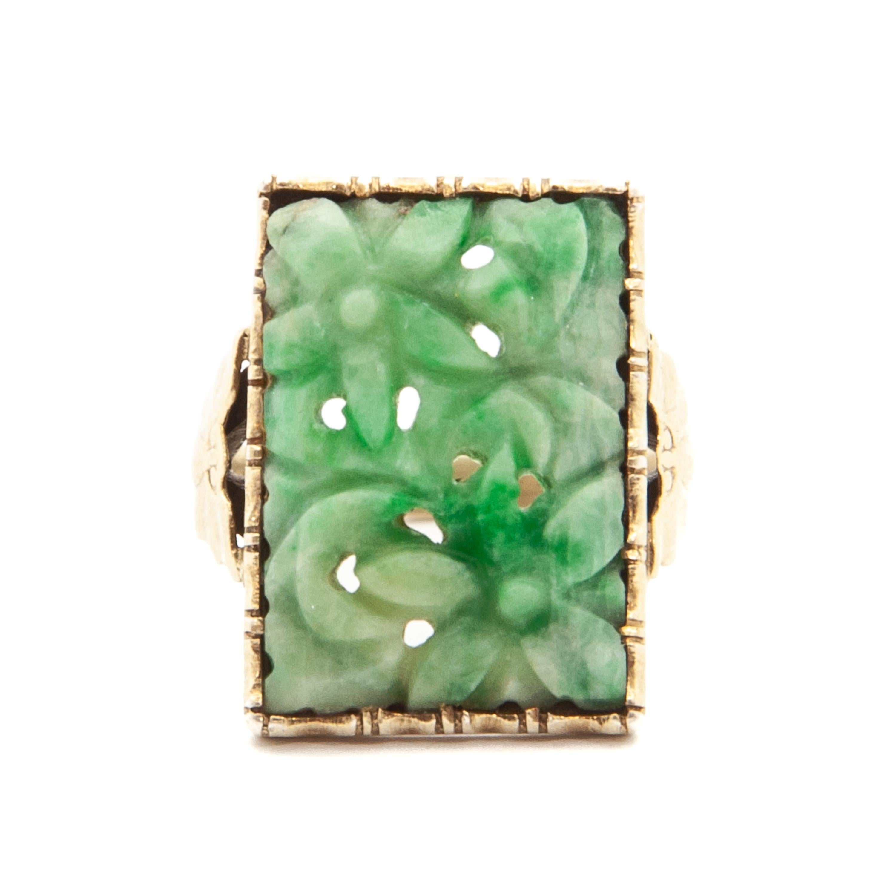 An Art Deco carved green jade ring set with a rectangular 835 gilded silver panel. The design is characterized by her floral carved motifs featuring bat shoulders. The ring dates from early 20th century. Beautifully Chinese green jade mounted in