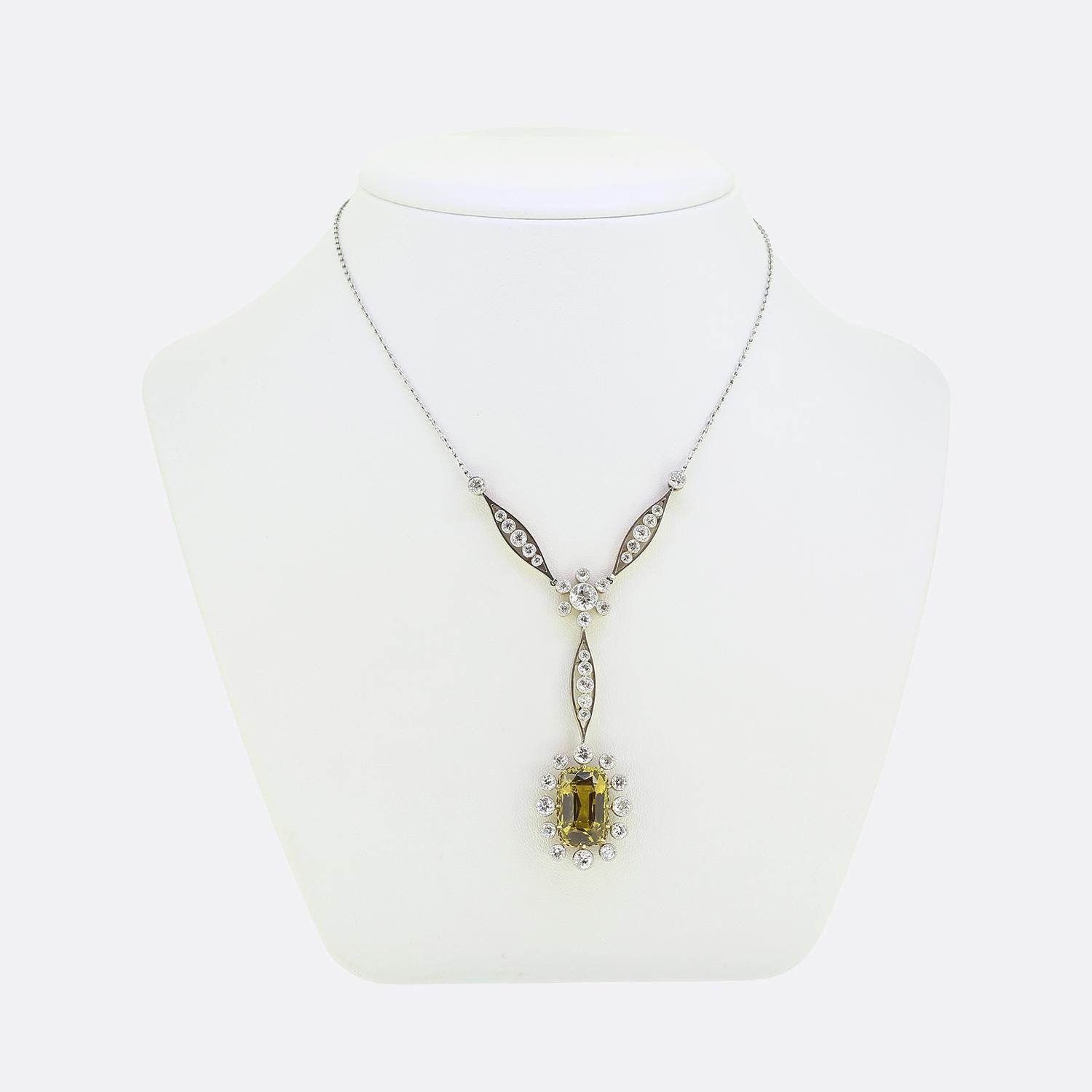 Here we have a fabulous drop necklace featuring a captivating ensemble. Crafted with precision, this platinum piece showcases an impressive 8.50 carat chrysoberyl at the centre, elegantly surrounded by a frame of round faceted old cut diamonds. The
