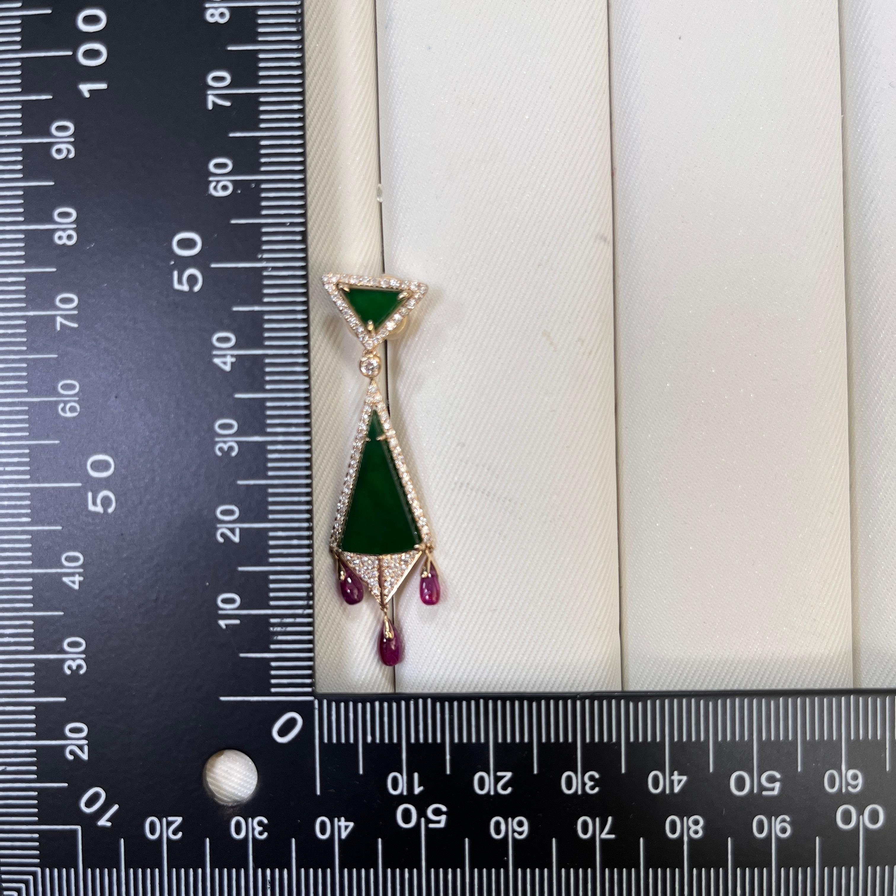 Audacieuses et architecturales, ces boucles d'oreilles allient la précision géométrique aux accents luxueux des pierres précieuses. Réalisé en or jaune 14 carats, le design présente des panneaux triangulaires de jade vert foncé (8,5 ct) encadrés de