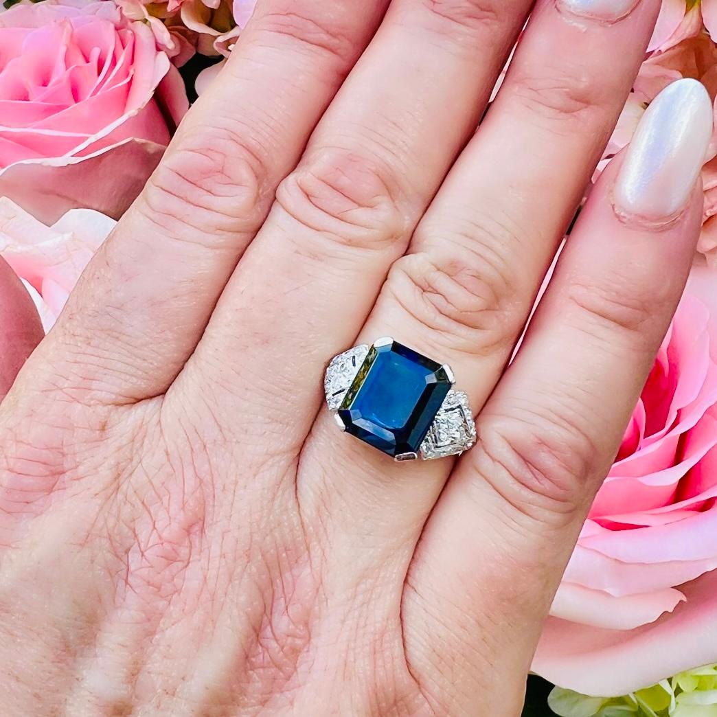 A piece from a bygone era that is as in fashion today as it was a hundred years ago. This platinum Art Deco ring features an 8.66 carat blue sapphire set with four prongs and surrounded on either side by sparkling diamonds weighing a total of 0.39