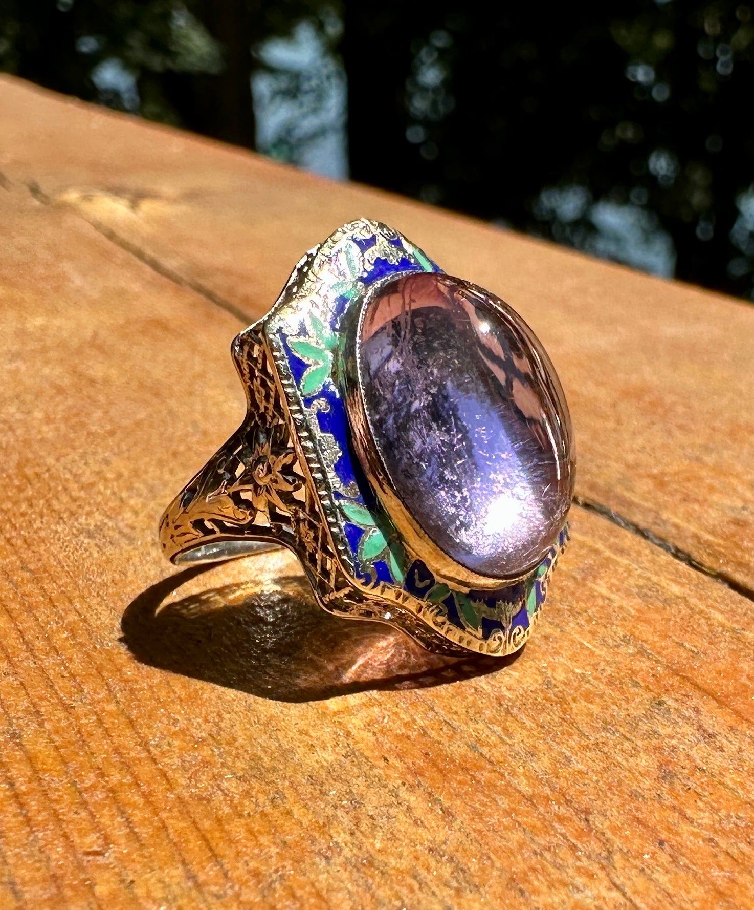 This is an extraordinary antique Art Deco Enamel Ring with a stunning nine Carat Amethyst in the center with gorgeous green and blue enamel decoration in 14 Karat White Gold surrounding the Amethyst cabochon.  The amethyst is large and magnificent