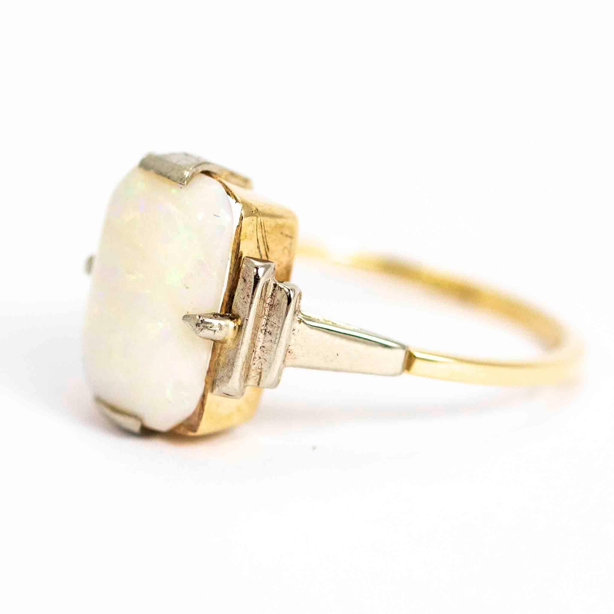 A beautiful vintage Art Deco ring. Set with a large rectangular opal between classic stepped shoulders, typical of the Art Deco period. The stone settings and shoulders are modelled in white gold, the band of the ring is modelled in 9 carat yellow