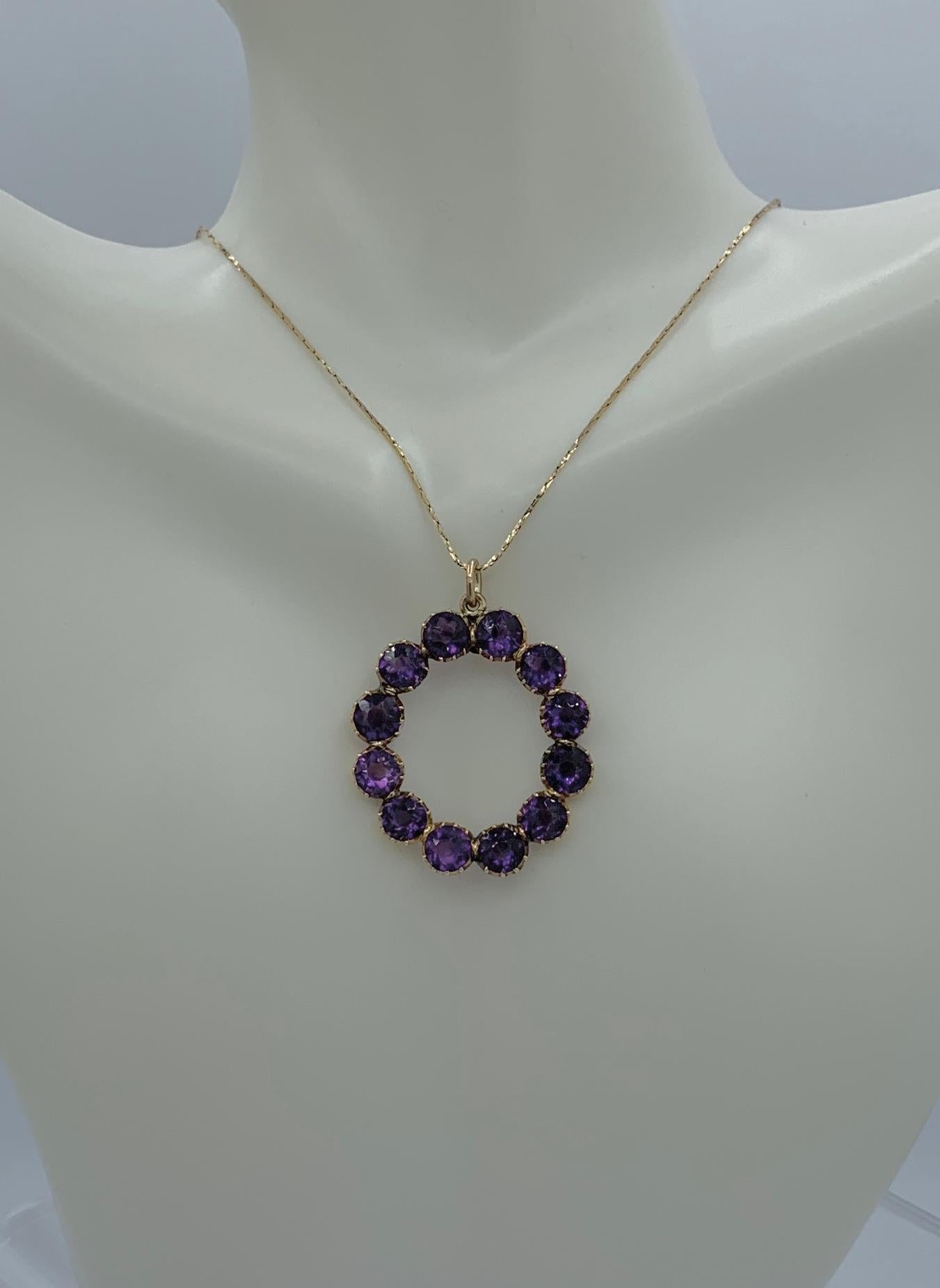 This is a beautiful antique 9 Carat Siberian Amethyst Victorian - Art Deco Circle Pendant in 14 Karat Gold.  The oval shaped pendant is set with 12 round faceted Siberian Amethysts that total approximately 9 Carats.   The color and radiance of the