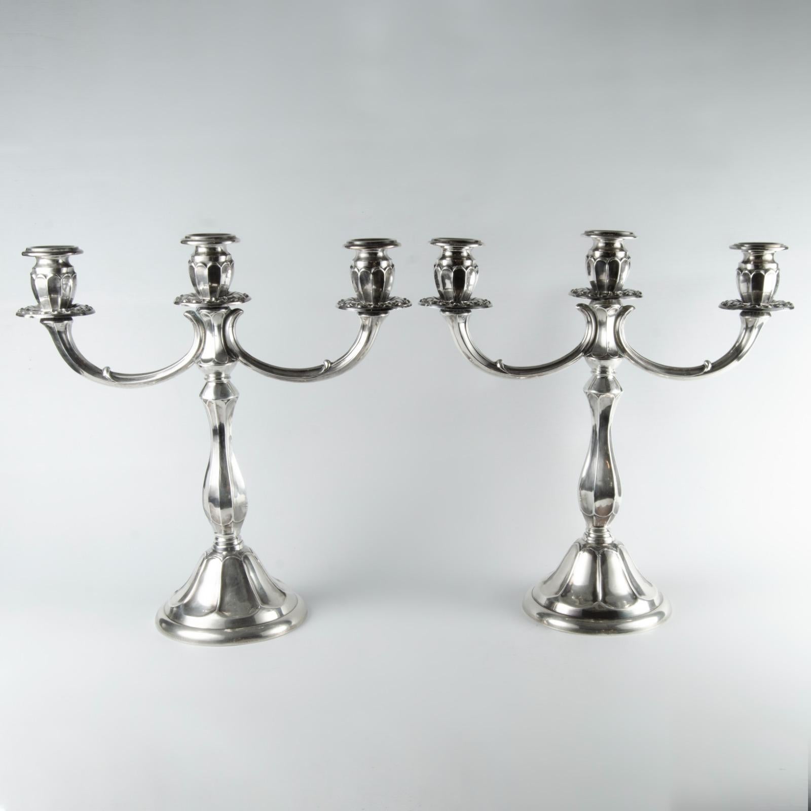 Art Deco 925 Sterling Silver Candle Holders
Pair of silver candelabras with an elegant design. Each has a round base and a slender stem that widens toward the center, with arms that extend in graceful curves holding three candle holders. The
