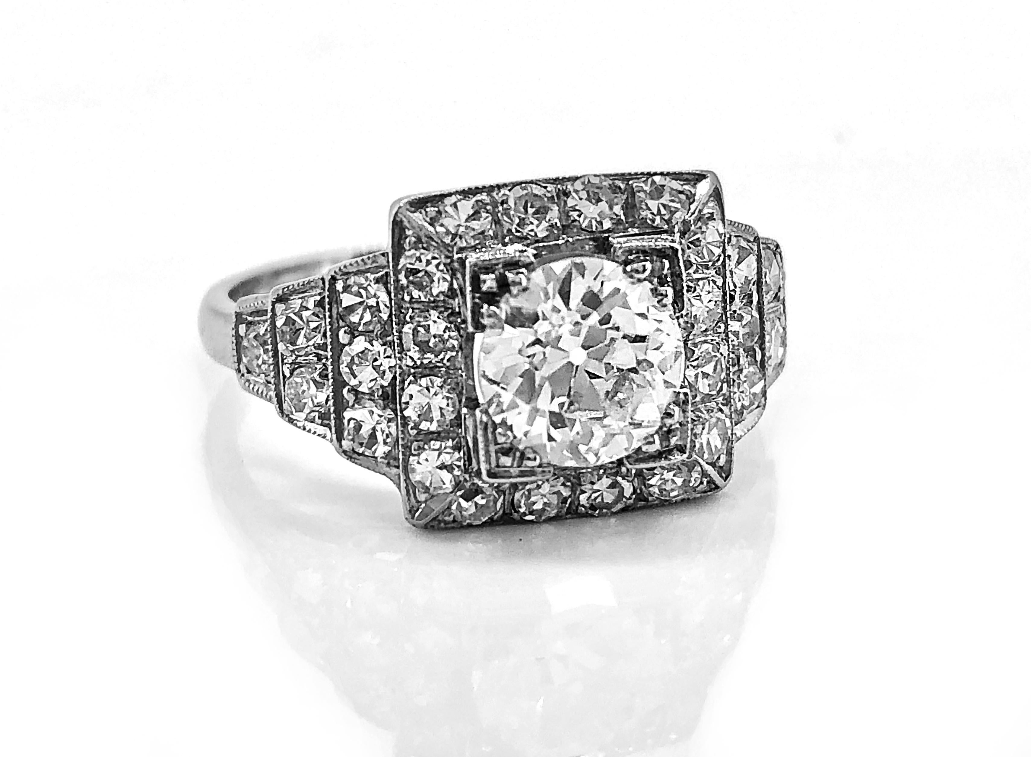 A beautifully designed and very eye appealing antique engagement ring, this square format is highlighted by a .94ct. apx. European cut diamond. The diamond is of excellent H color and VS2 clarity. The ring is further enhanced by .75ct. T.W. apx. of