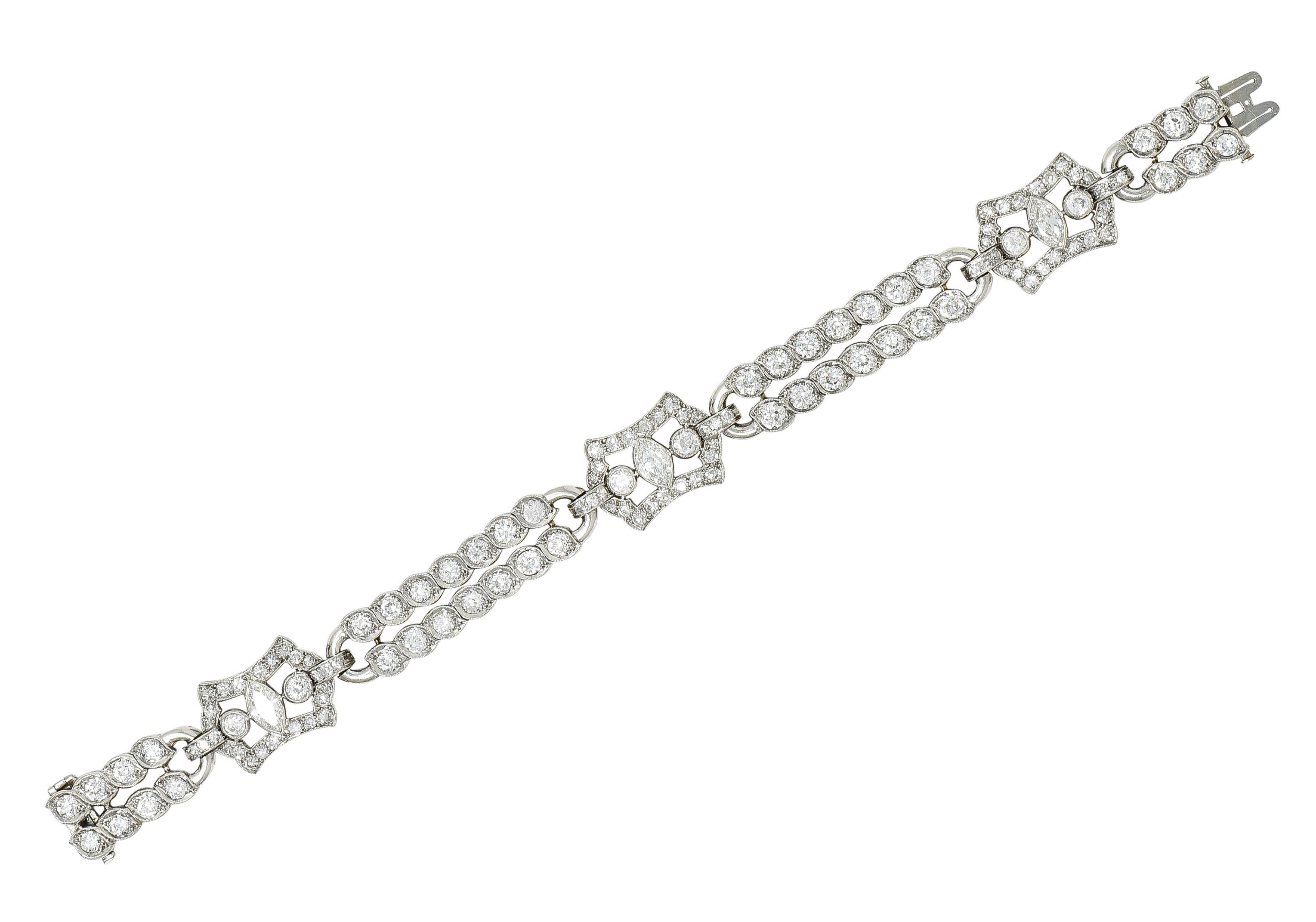 Comprised of two rows of hinged links alternating in pattern with pierced cartouche shaped stations. Each station centers marquise cut diamonds weighing approximately 1.20 carat total - I color with VS1 clarity. With old European cut diamonds bead