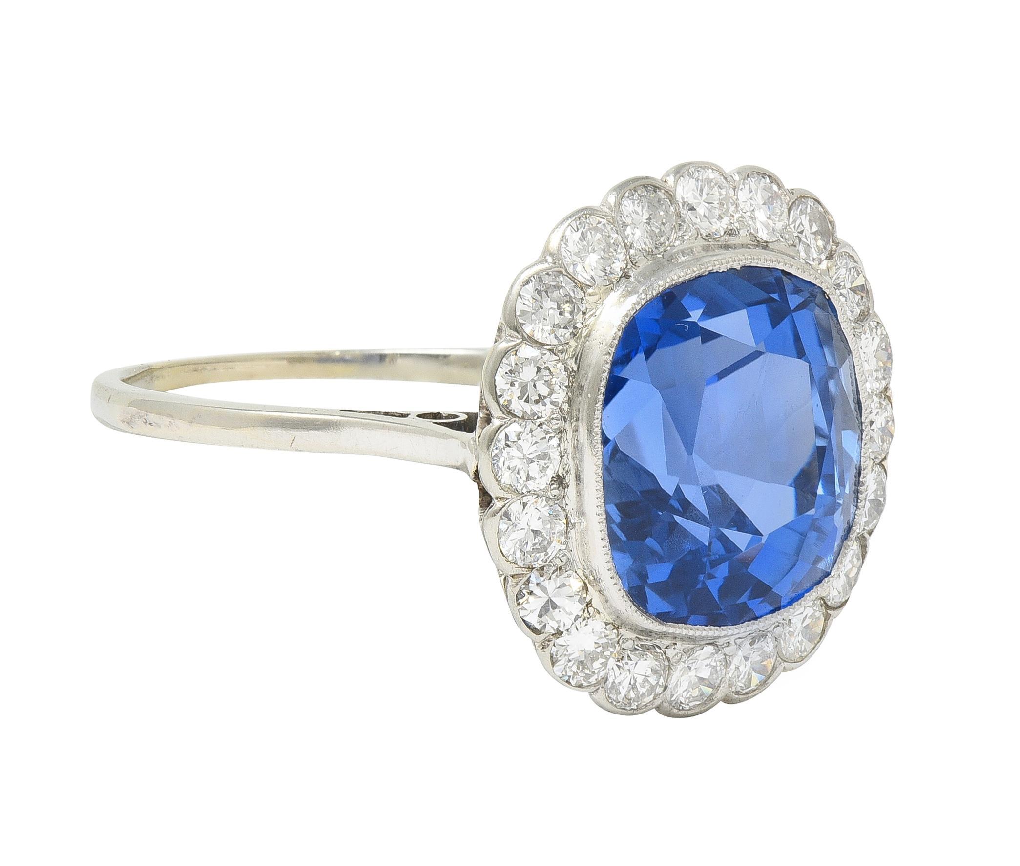 Centering a cushion-shaped mixed-cut sapphire weighing approximately 8.87 carats 
Natural Ceylon in origin with no indications of heat treatment - transparent medium blue
Bezel set with a halo surround of old European cut diamonds 
Weighing