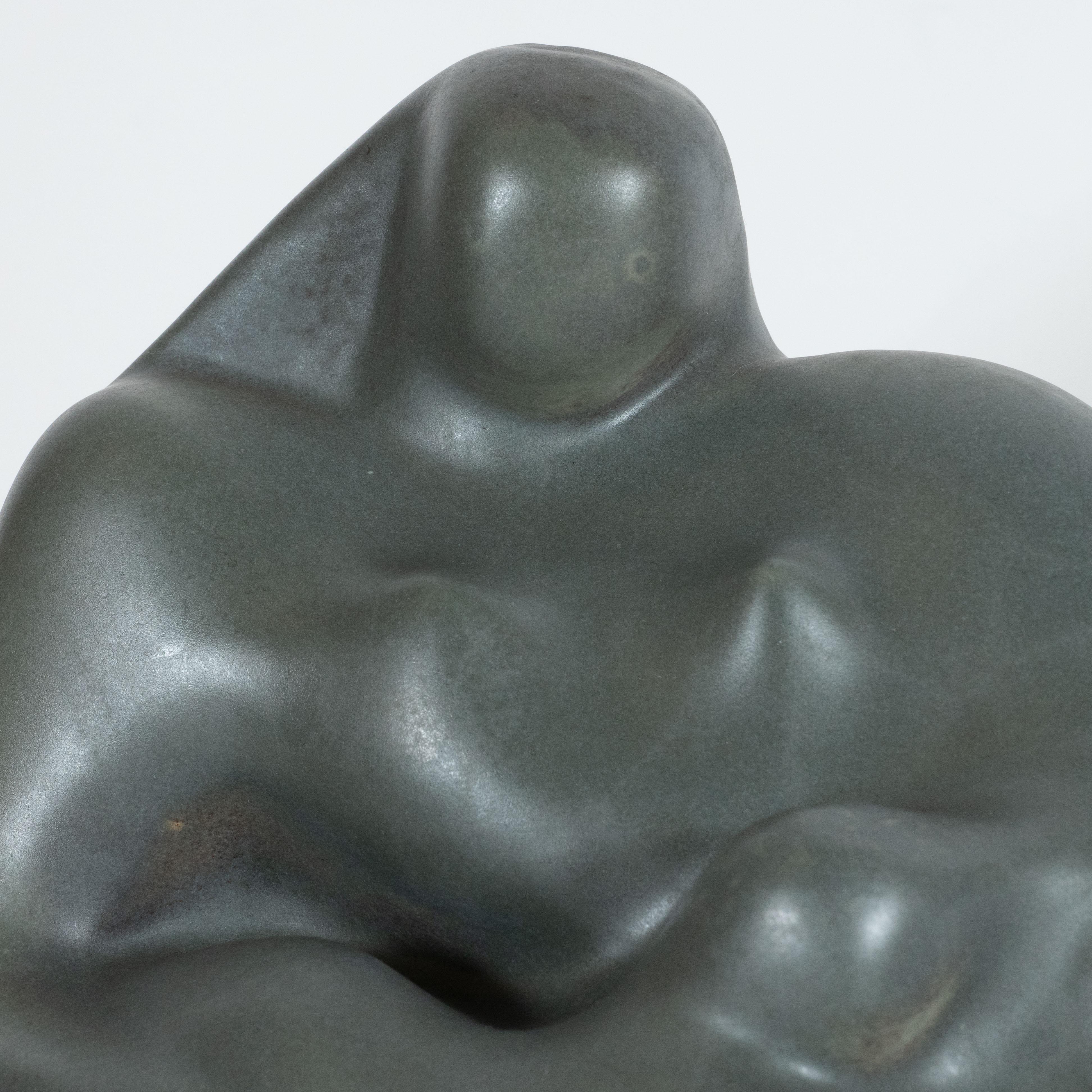 This sophisticated Art Deco sculpture was realized in the United States circa 1940. It features a highly abstracted and stylized rendition of a mermaid holding a child. The mermaid, rendered in loose undulating lines and curvilinear forms, has a