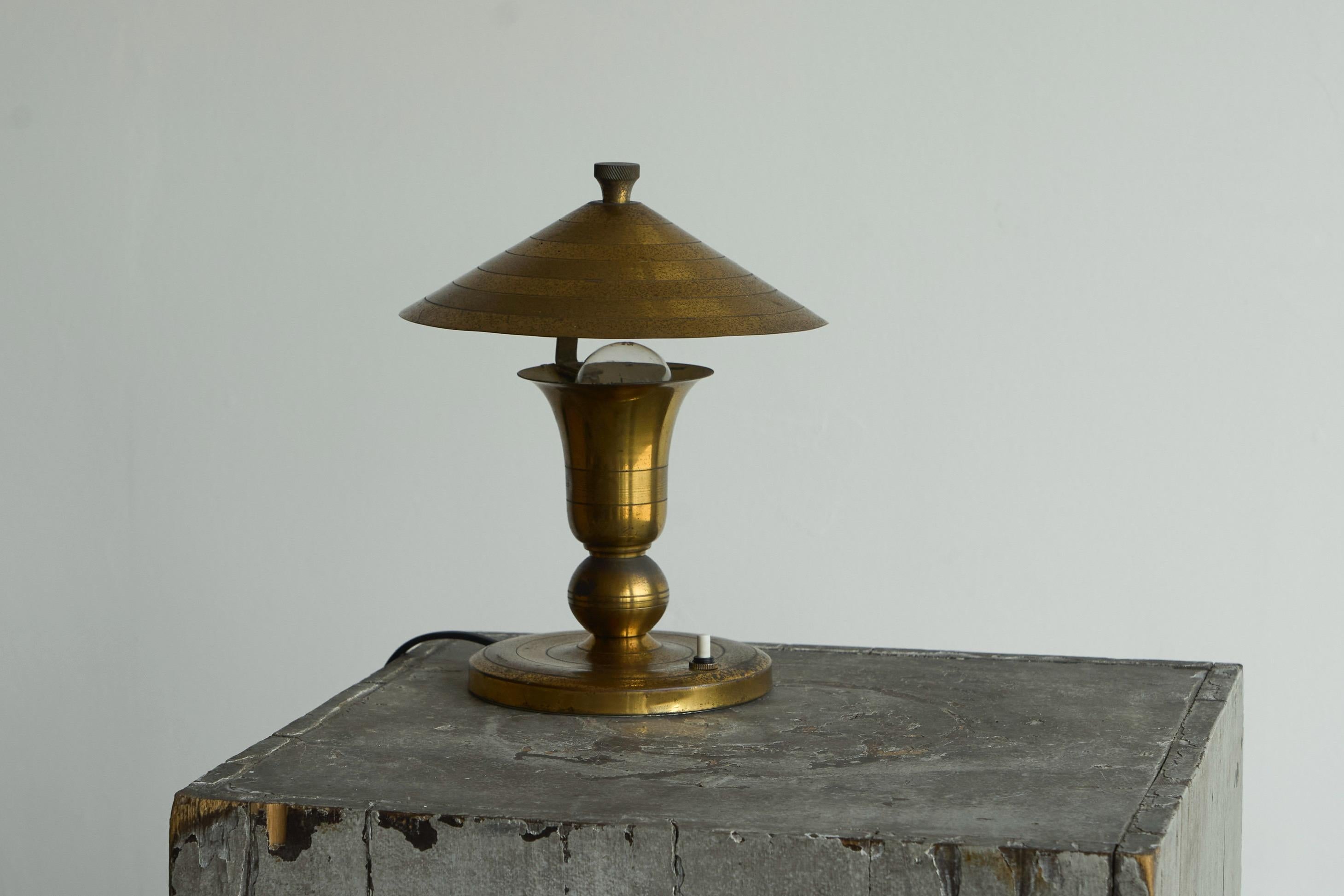 Art Deco Accent Table Lamp in Patinated Brass, Europe, 1940s.

A small but very nice art deco table lamp in nicely patinated brass. It features an unusual design with a ‘floating’ shade - fun and elegant at the same time. Also the combination of