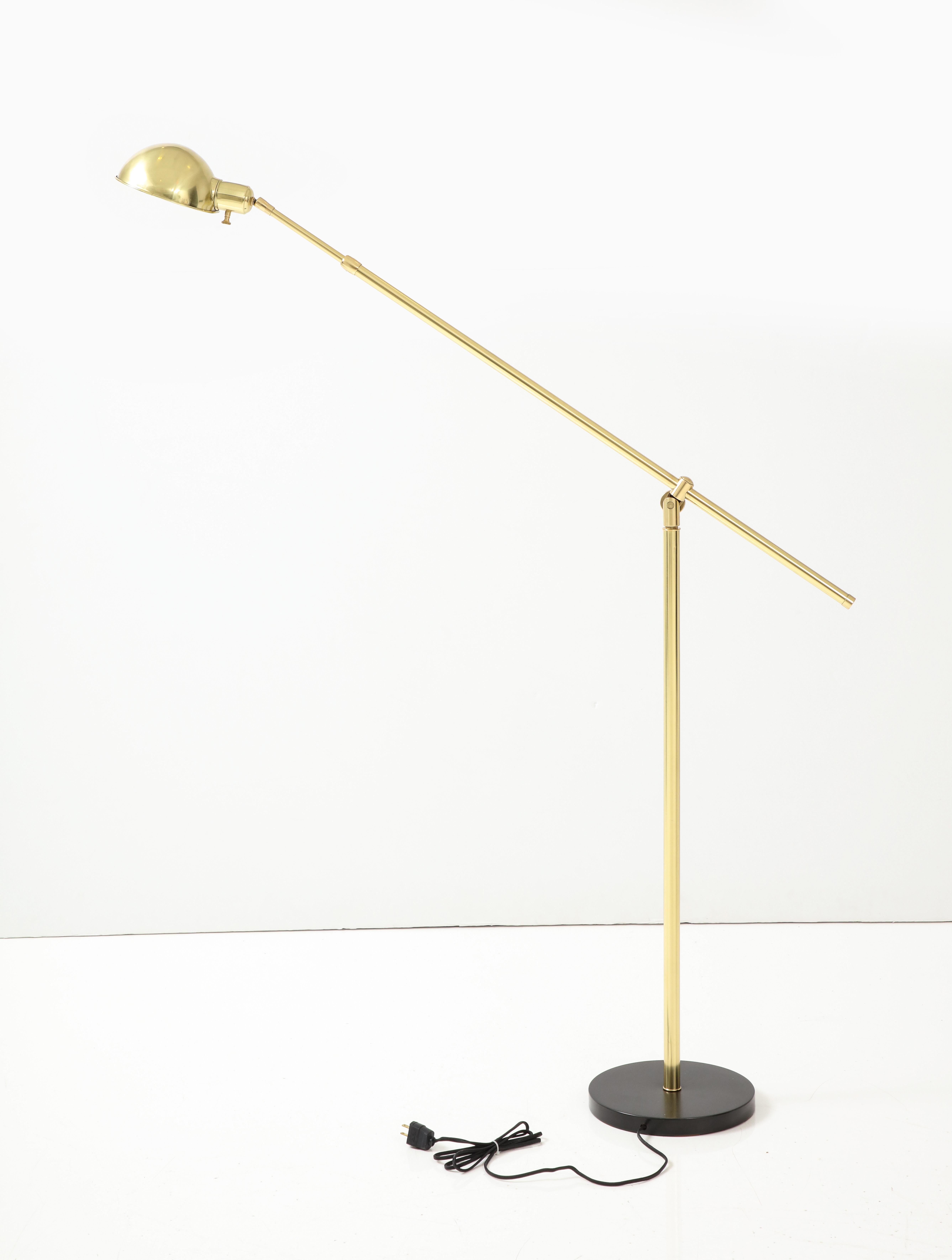 Architectural adjustable brass floor lamp on a darkened bronze base featuring a swiveling brass hood. Rewired by an UL listed electrician.