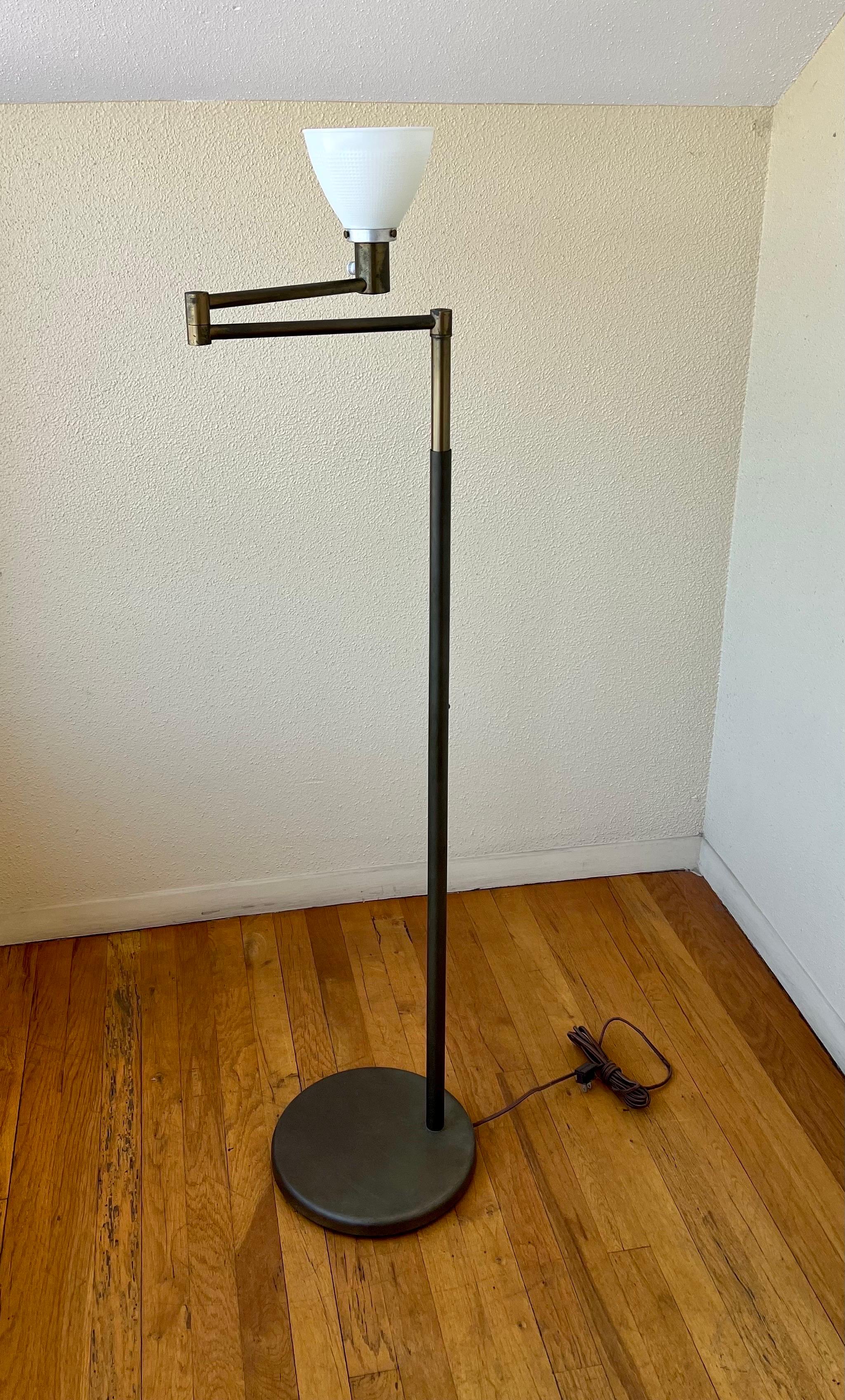Early production on this floor lamp design by Walter Von Nessen for Nessen Studios, in brushed brass finish, great patina the arm moves back and forward and the pole goes up and down comes with the original lampshade that has been redone and plastic