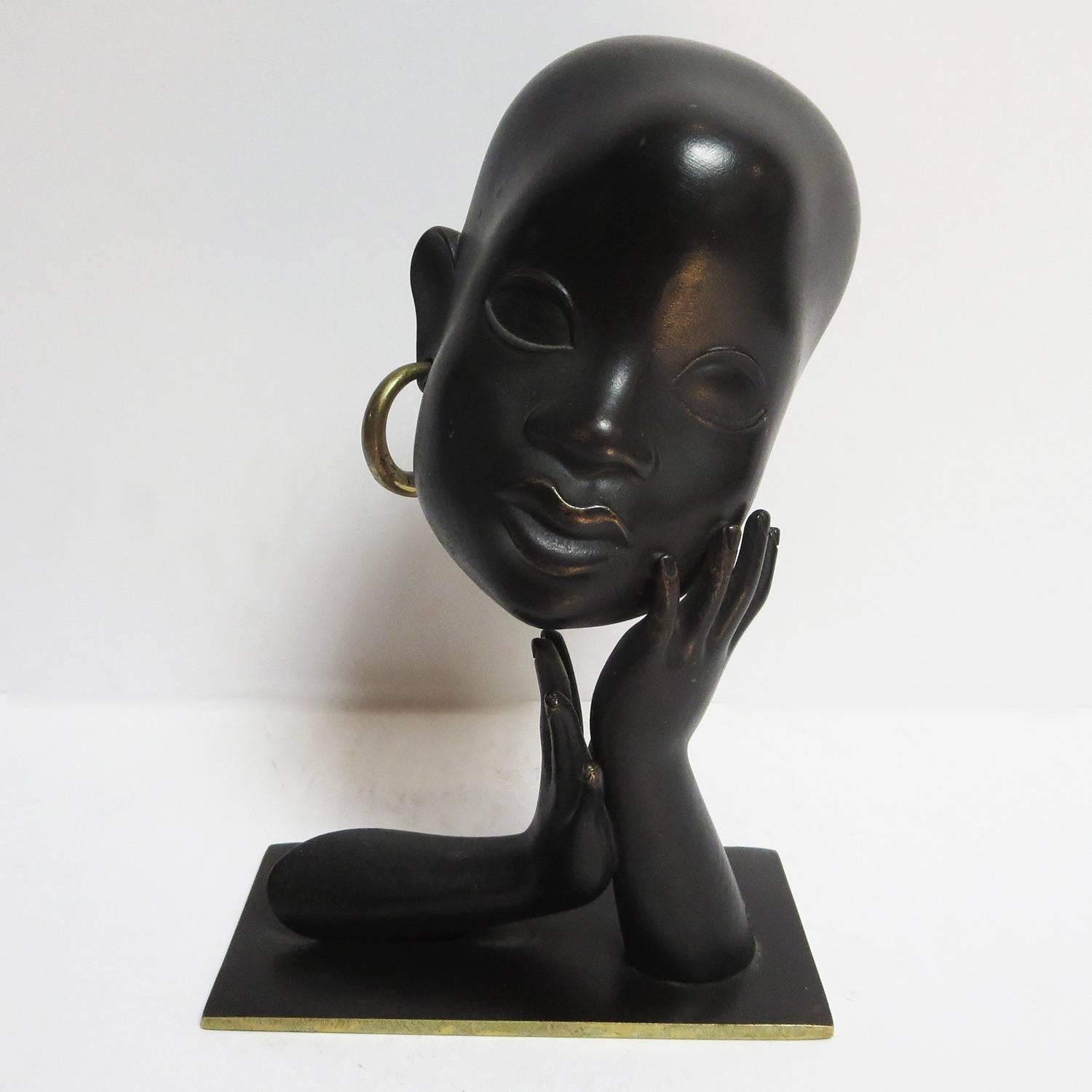 This lovely African sculpture was created by Karl Hagenauer of Vienna Austria. There was a fascination with African fashion and design throughout Europe in the Art Deco period. The sculpture is cast bronze, with a blackened patina. The original