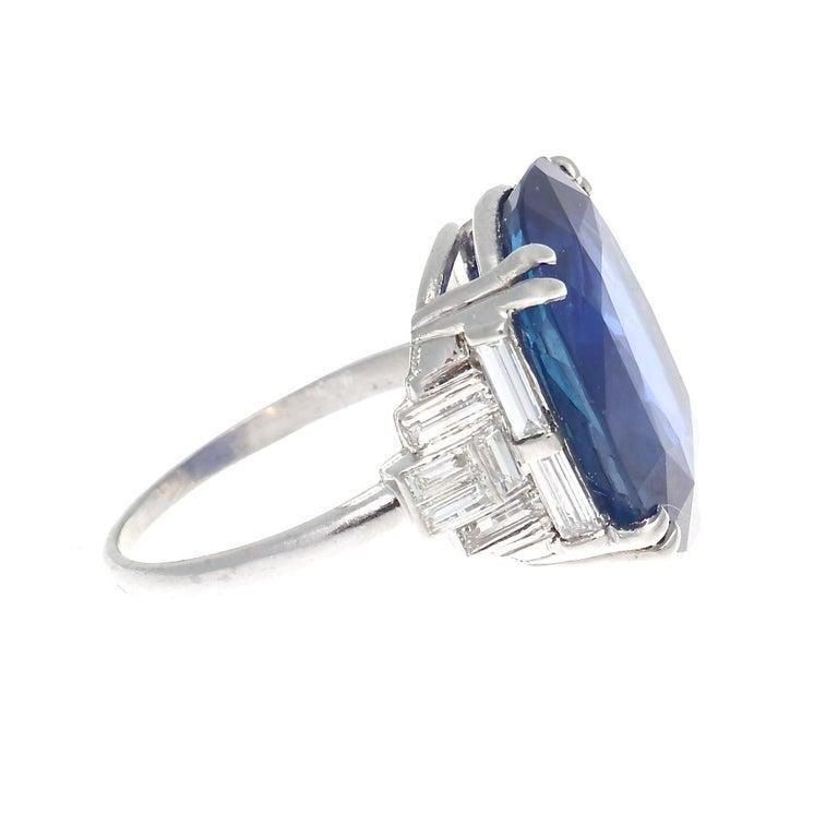 Featuring an AGL certified 14.33 carat Ceylon sapphire that has no indications of heat treatment. The sapphire displays strong royal blue color throughout, a rarity in a stone this size. Accented with colorless baguette cut diamonds. Crafted in