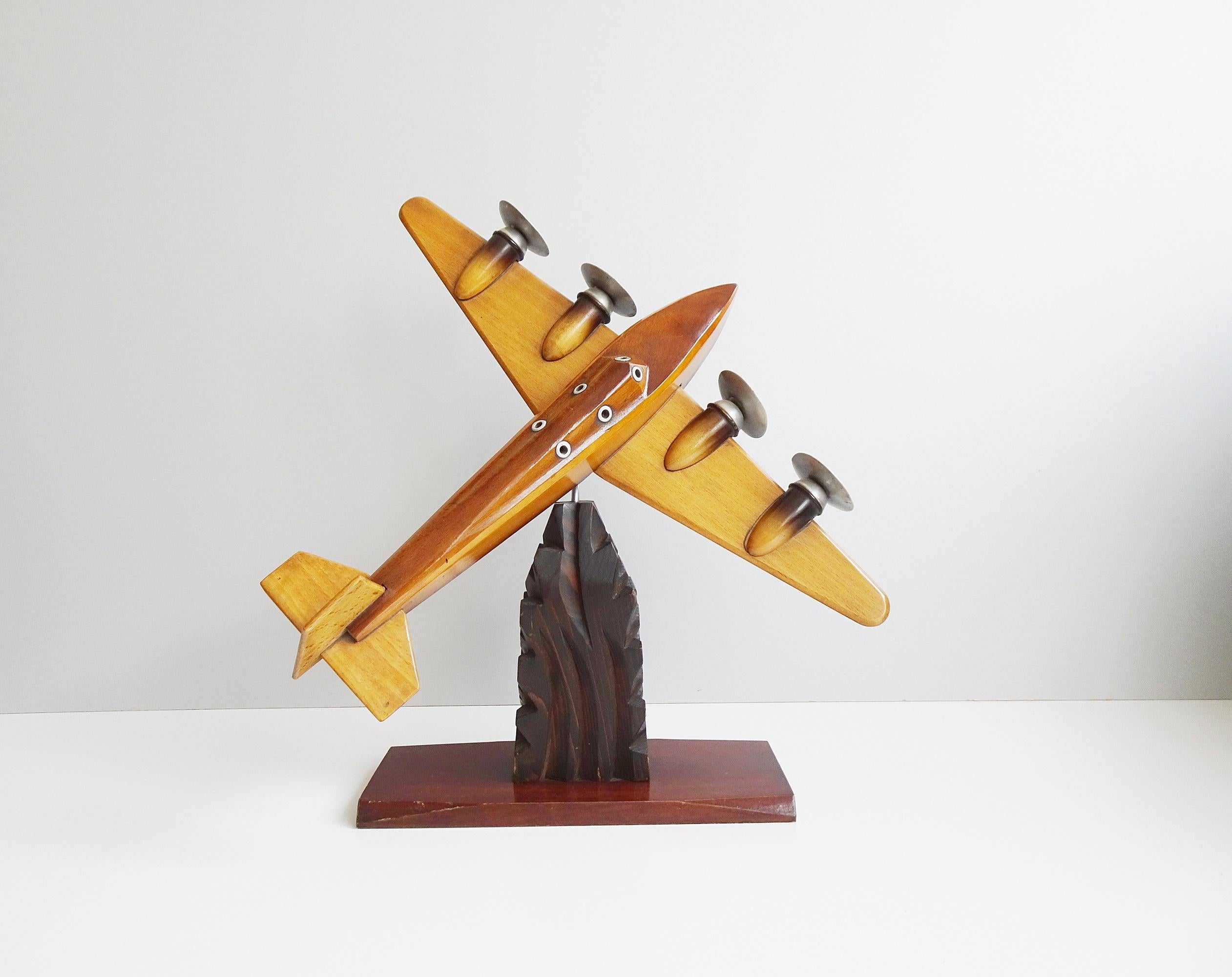 This wooden airplane is a handcrafted model airplane from the 1940s. The sculpture is built on a carved base with a 360 degree swivel joint. Turn it into high flyer, cross flyer or high flyer. High-quality processing of different woods, with fine