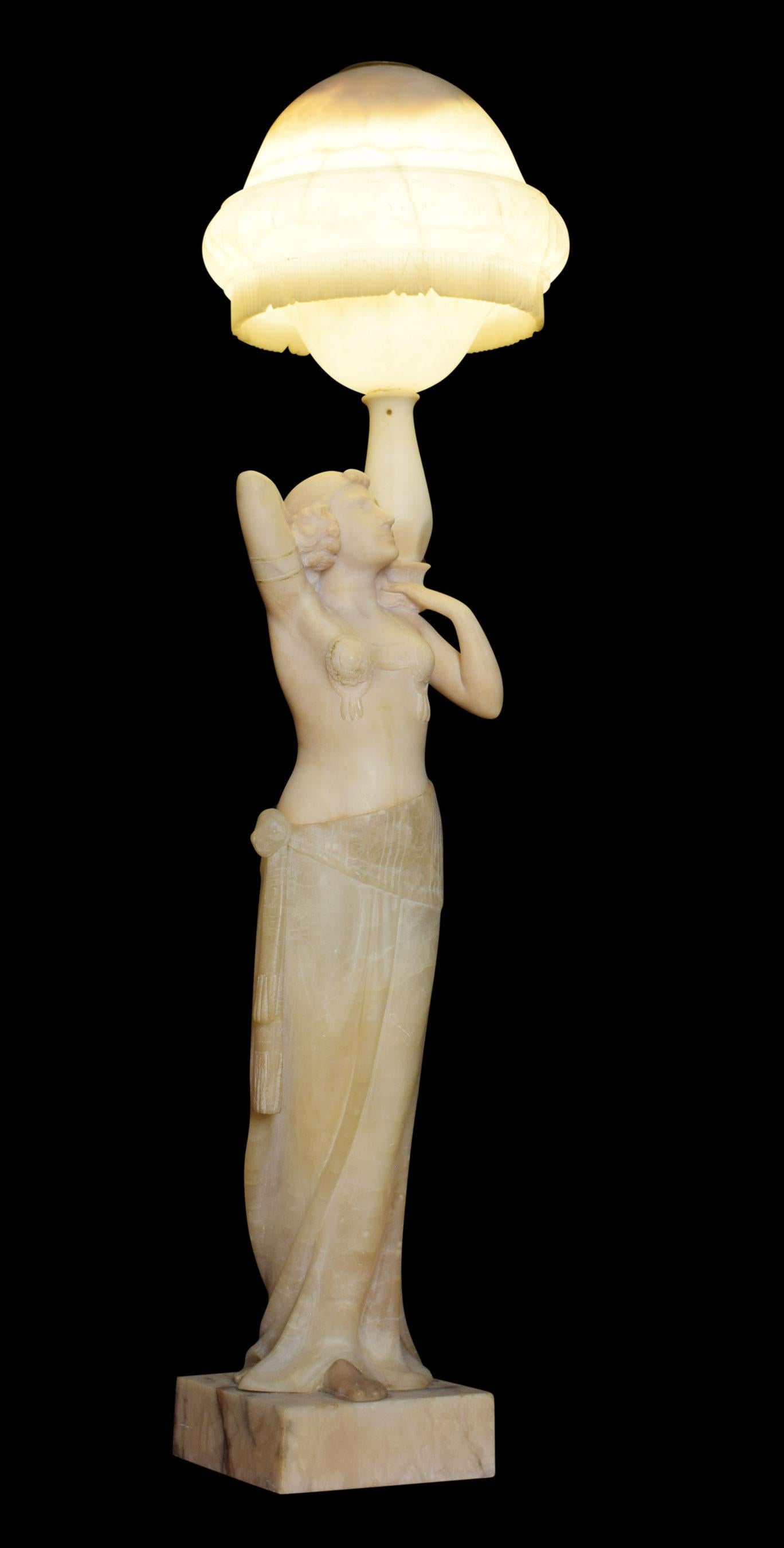 Art Deco alabaster figural lamp modelled as an Egyptian Revival dancing girl having arms raised below the bowl-shaped shade. The lamp has been rewired.
Dimensions
Height 40 inches
Width 11.5 inches
Depth 11.5 inches.