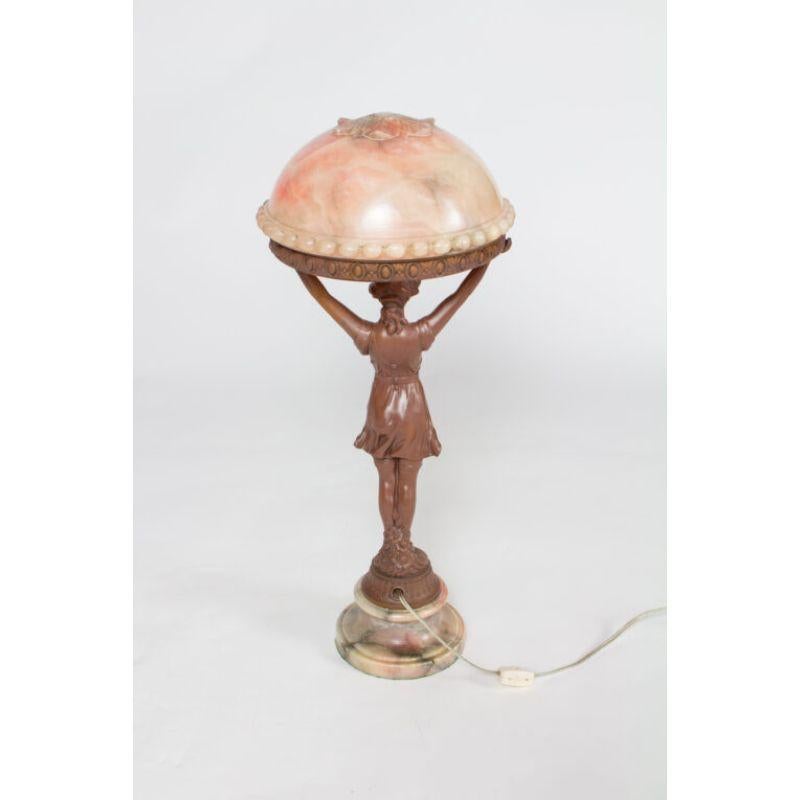 Alabaster and painted metal table lamp. Girl with a flowing dress holding up the round alabaster shade. Figure restored with original painted finish. Pink alabaster shade.

Material: Alabaster, White Metal
Style: Art Deco, Traditional
Place of