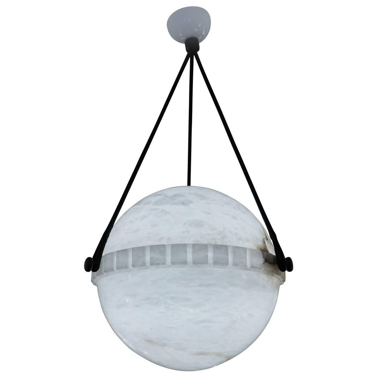 More unusual than the bowl shaped pendants, the globe alabaster features a lower half with a crisp dental motif on the central band and suspends on a set of three brushed nickel flattened balls. The upper half nestles perfectly into the banding and