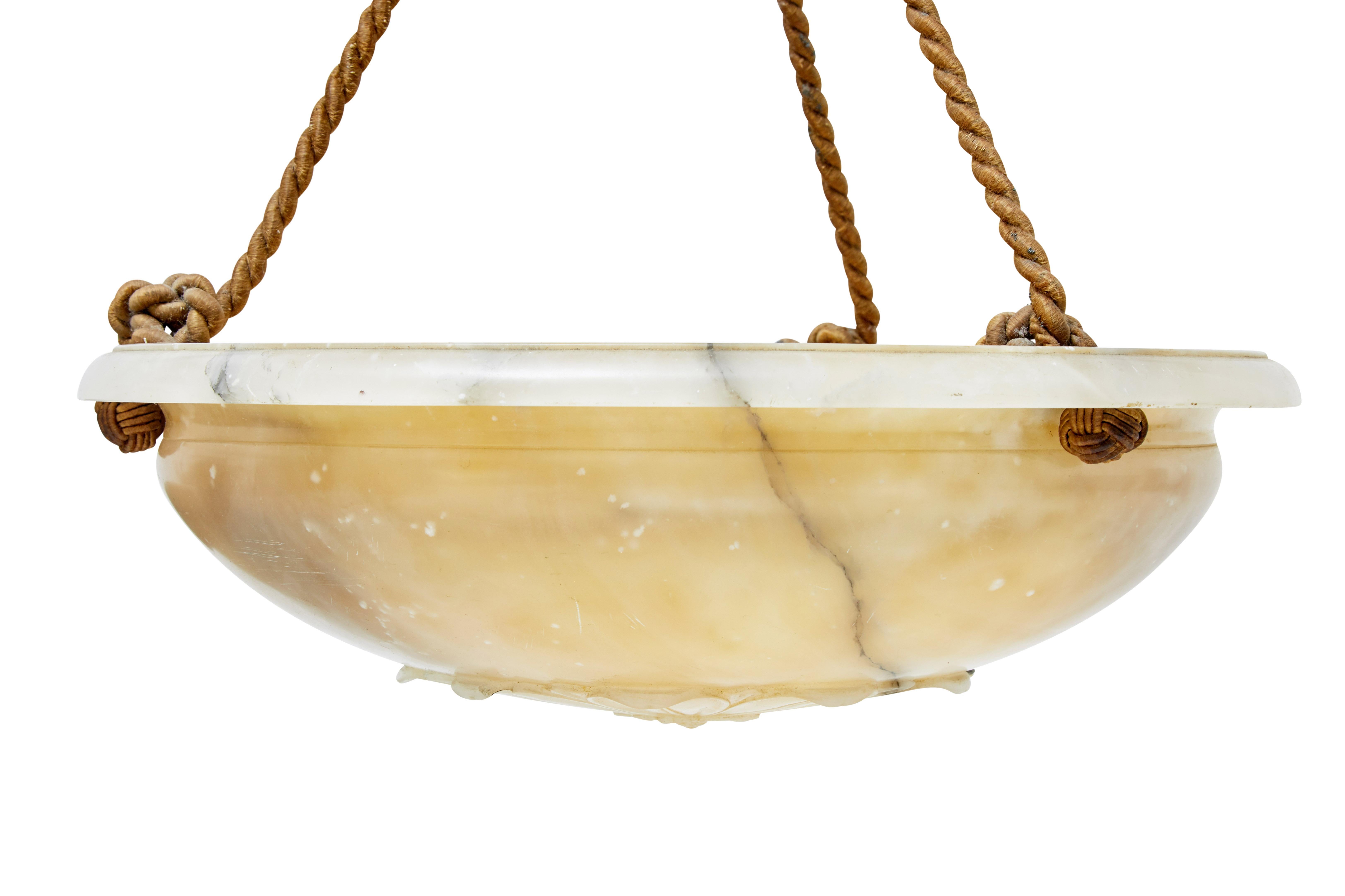 Good quality art deco alabaster chandelier, circa 1920.

Carved alabaster dish with flower design on the underside base. Dish is suspended by three ropes, leading up to tassles and matching alabaster ceiling rose.

Fitted with three bulb