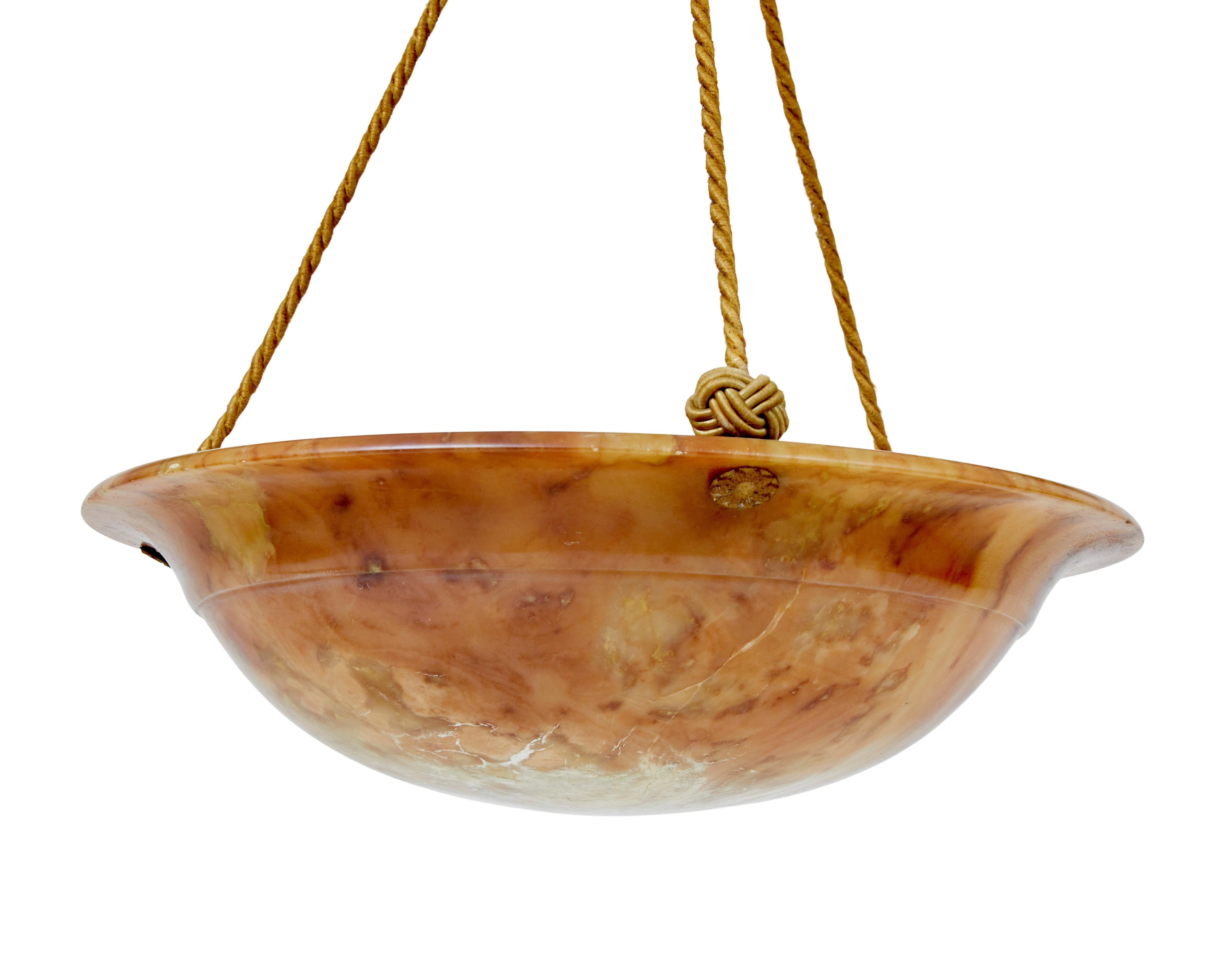 Lampada a sospensione in alabastro Art déco del 1930 circa.

Piatto luminoso in alabastro di buona qualità di proporzioni ridotte.

Piatto in alabastro intagliato, con rig e labbro.  Molteplici colori, dall'arancio al crema, con forti venature.  I