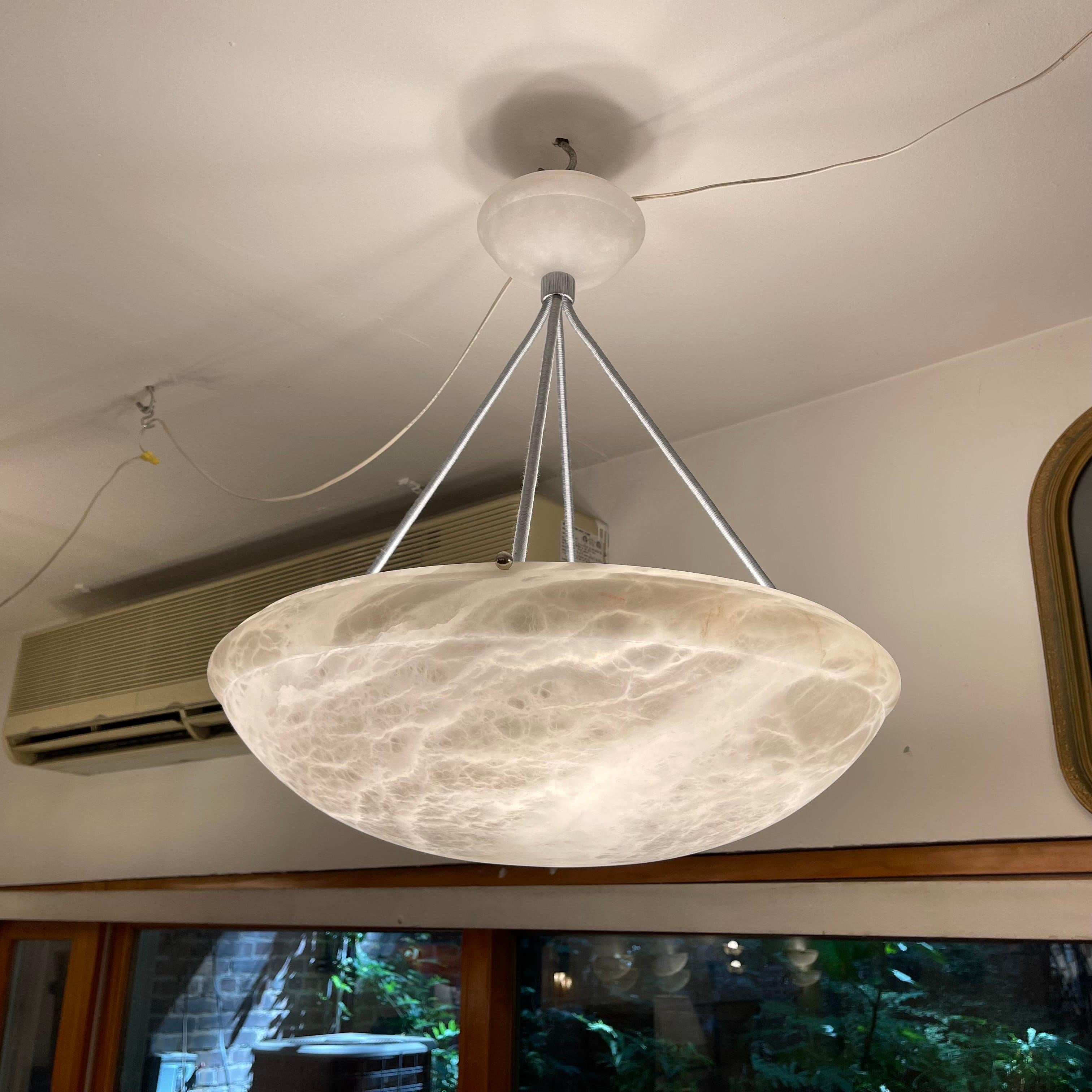 Pure white stone shows beautiful mineralization throughout the shade as well as the matching canopy. The drop may be customized at no additional charge, and the fixture mounts four standard bulbs. Purchase price includes customization if desired,